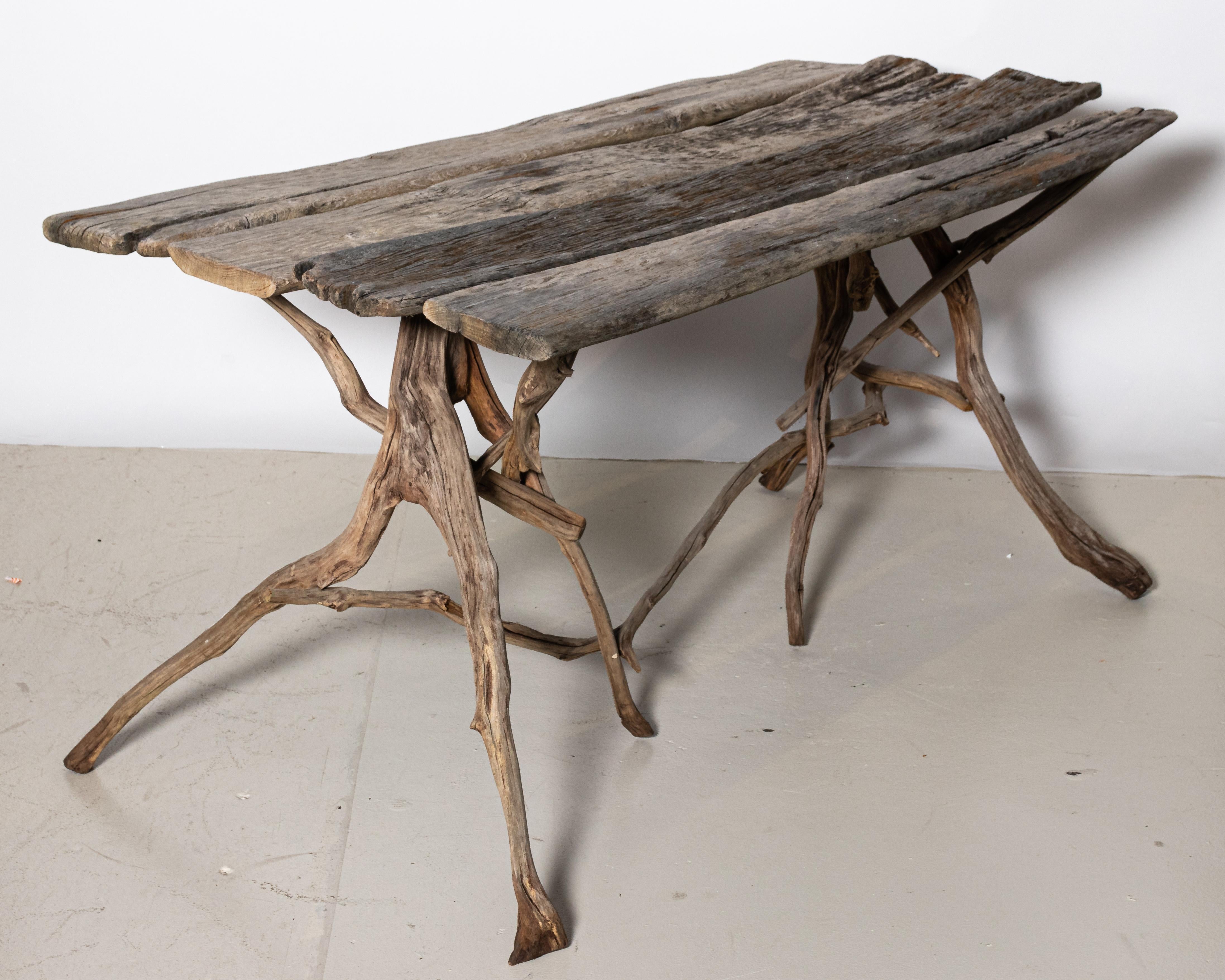 Estate made garden or outdoor dining table, circa early 20th century. The piece is composed of driftwood and reclaimed wood in a rough hewn finish. Please note of wear consistent with age and weathering due to exposure to the elements. Made in the