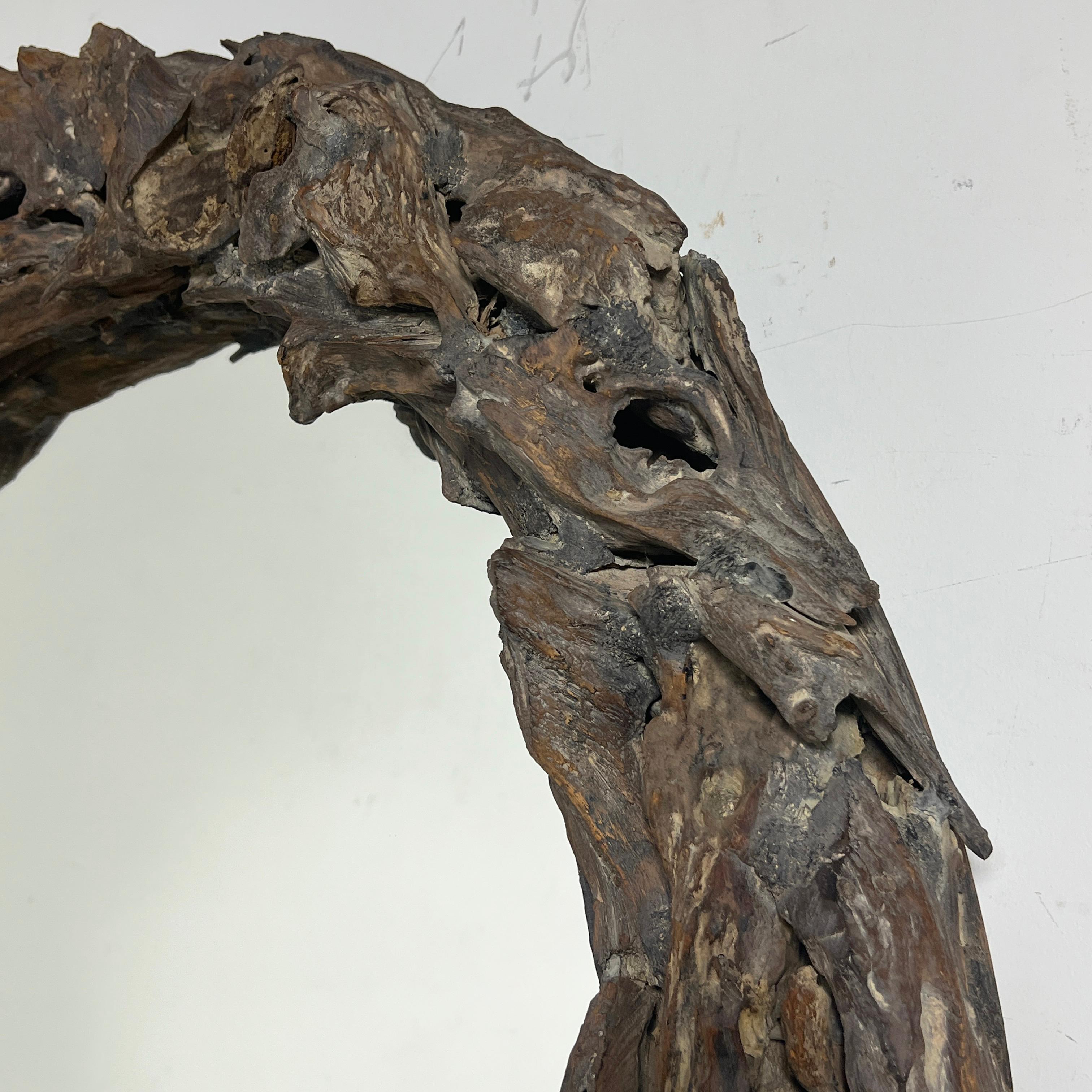 A rustic rondelle wall mirror in driftwood, circa late 20th century.