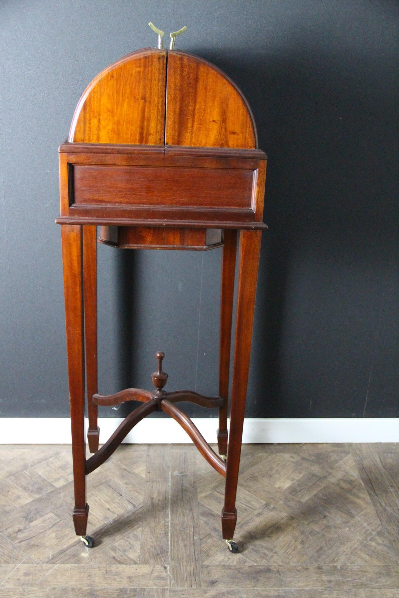 This English drink cabinet is particularly unusual and elegant.
Made of magnificent brown color walnut, from 1920's , Its bow shape top opens thanks to 2 solid bronze handles to reveal a breathtaking interiors made of a full set of 6  Baccarat