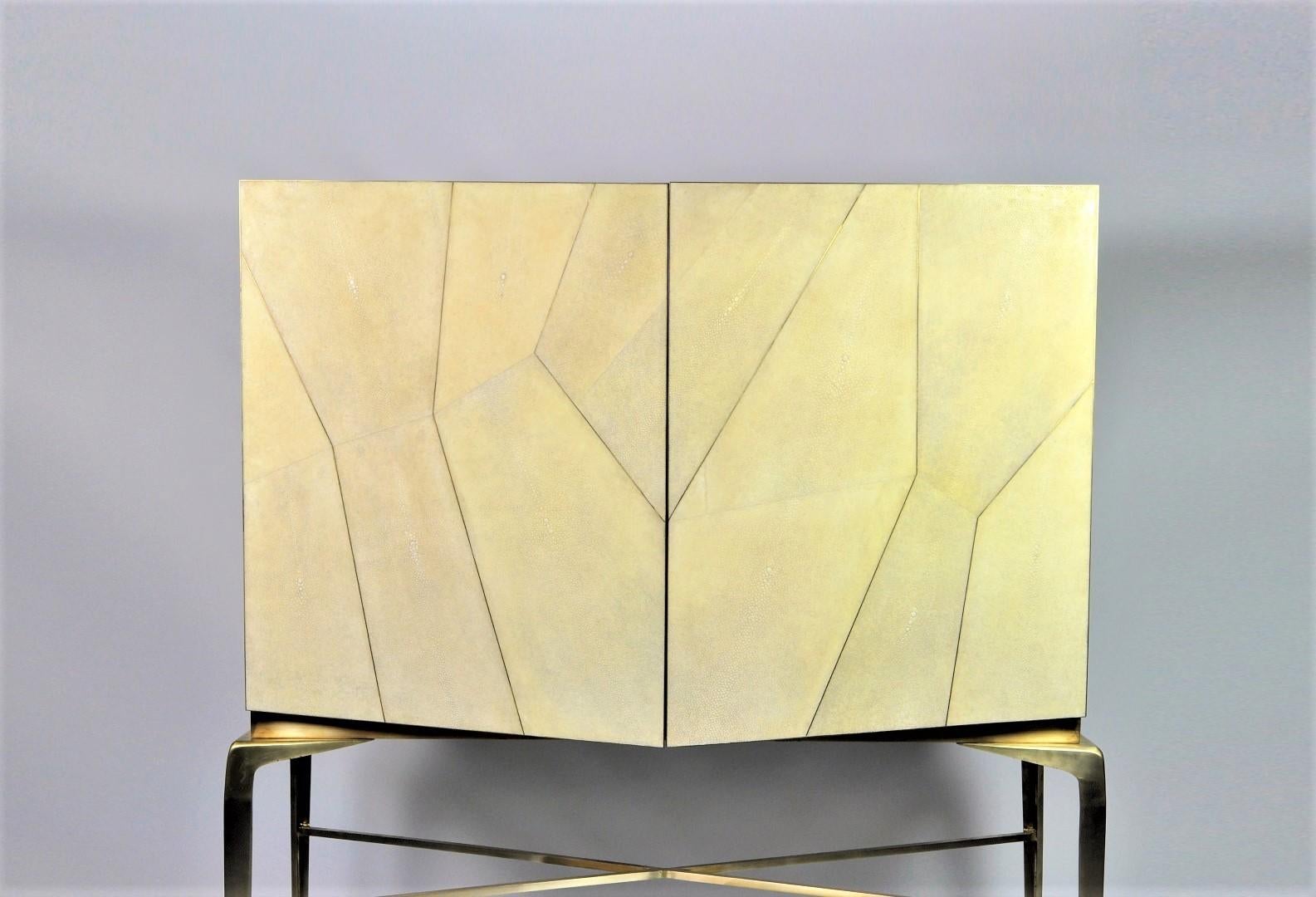 The drink cabinet Hydra is made of genuine shagreen with brass trims.
Its legs are in solid brushed brass.
This piece will settle very well in your living room and will magnify your best liquors.
The interior is in light oak veneer with a mirror