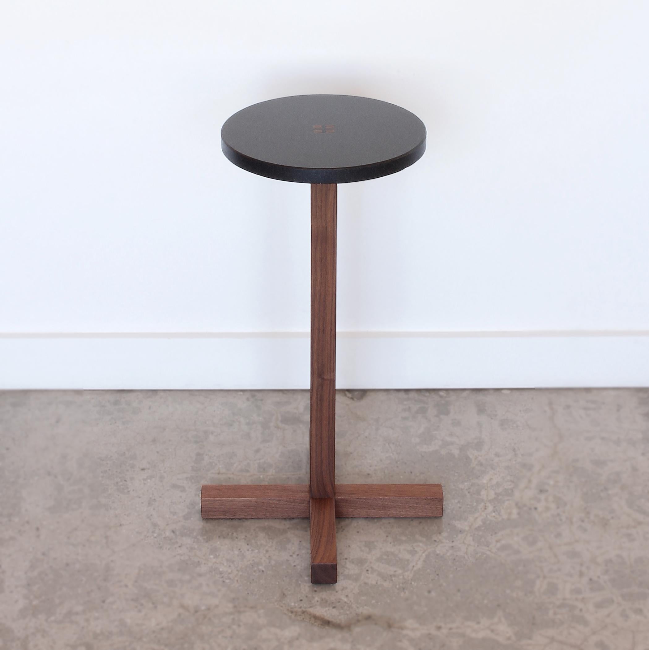 Drink Table with black granite top joined to a solid walnut base. Ebony wedges at center table top are driven permanently into place to combine stone top with wood base. The wood base is constructed with traditional Japanese joinery for structure