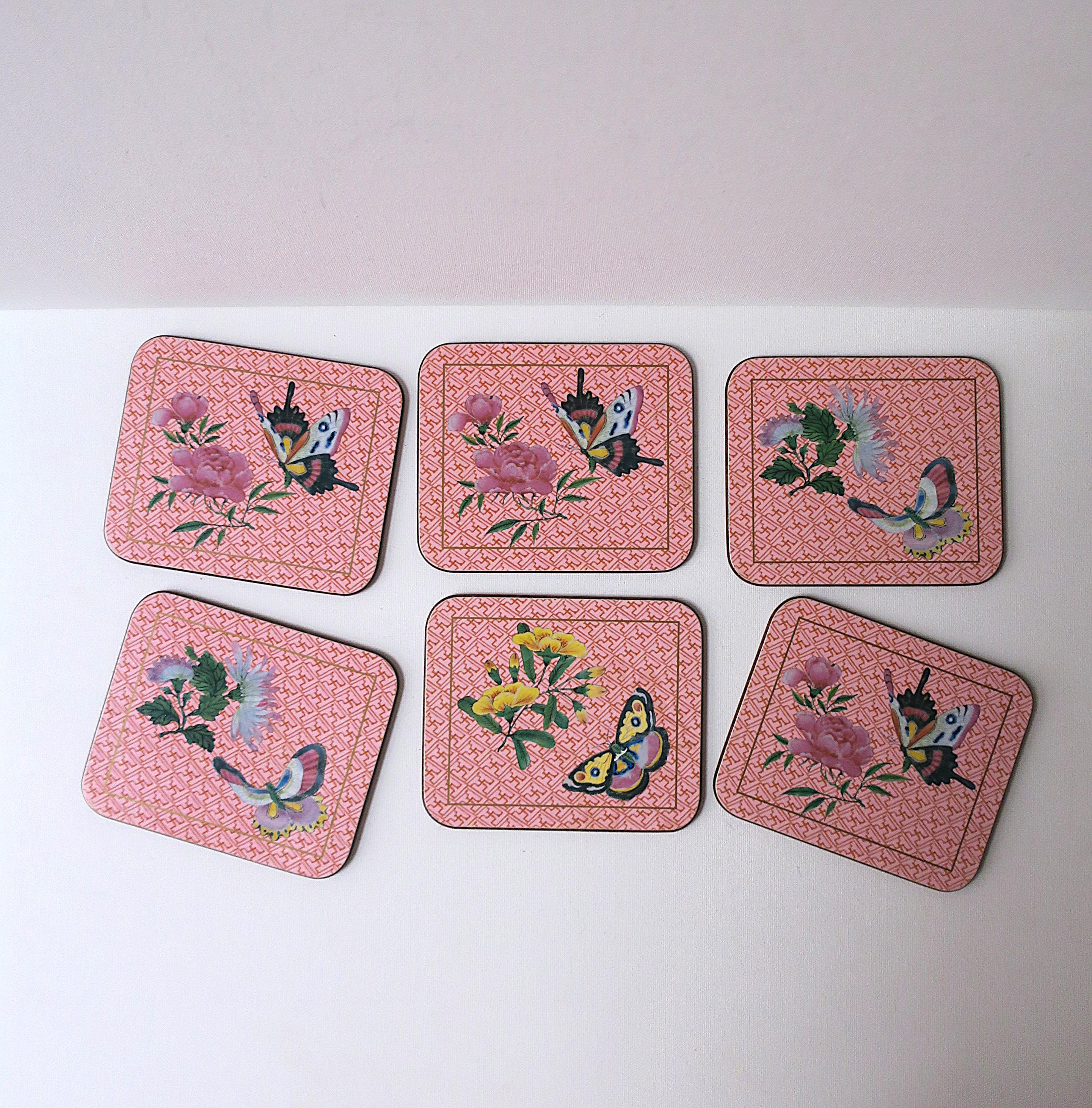 A beautiful set of six (6) cocktail drinks coasters in the Chinese Chippendale design style. circa late-20th century. Design includes flowers and butterflies with lattice-like ground/background design. Colors include pink, yellow, blue and green. A