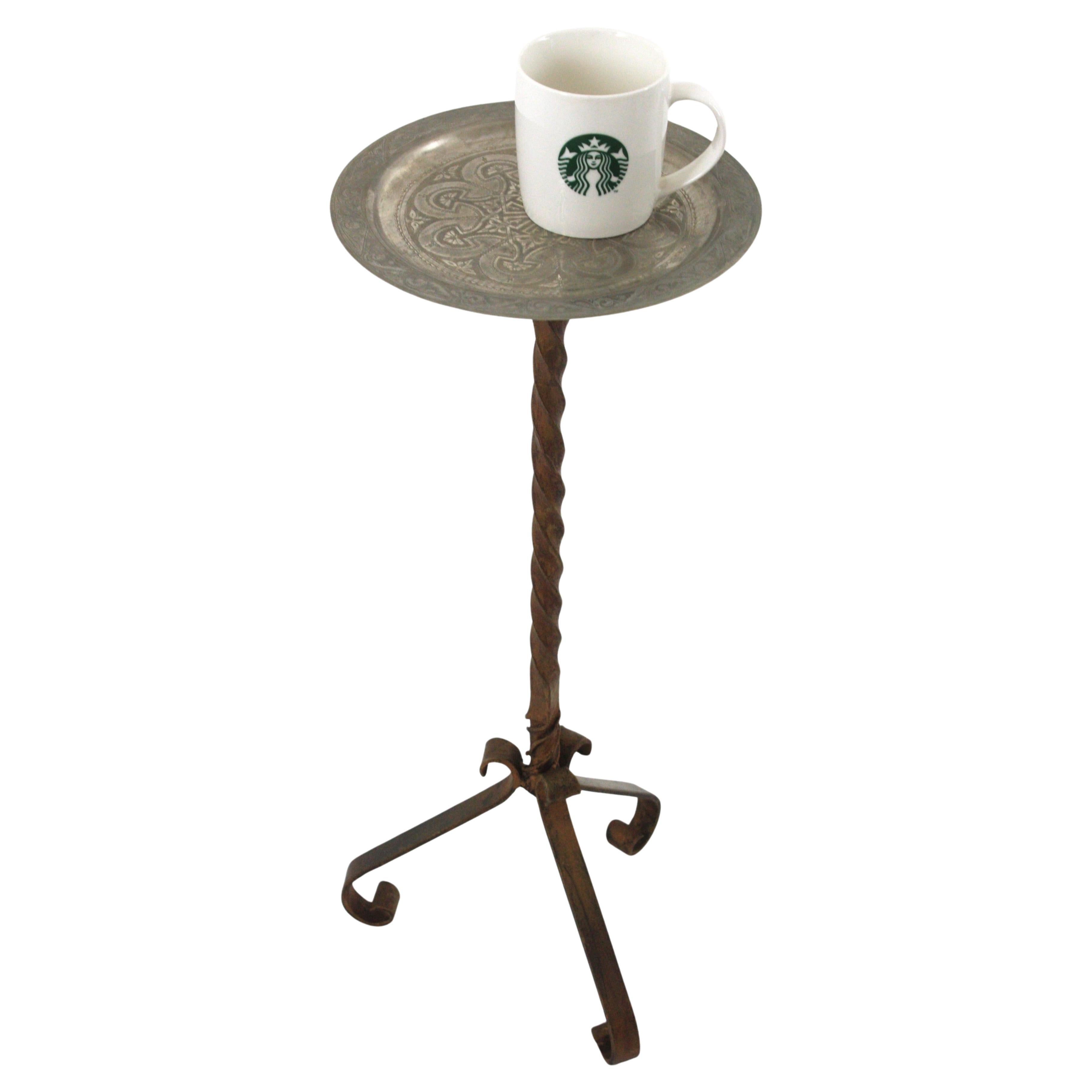 Mesa trípode para bebidas española de hierro y metal
____________________________________________________________
Mesita auxiliar de hierro forjado con base trípode y tablero de metal plateado. España, años 50
Esta mesa auxiliar trípode de hierro