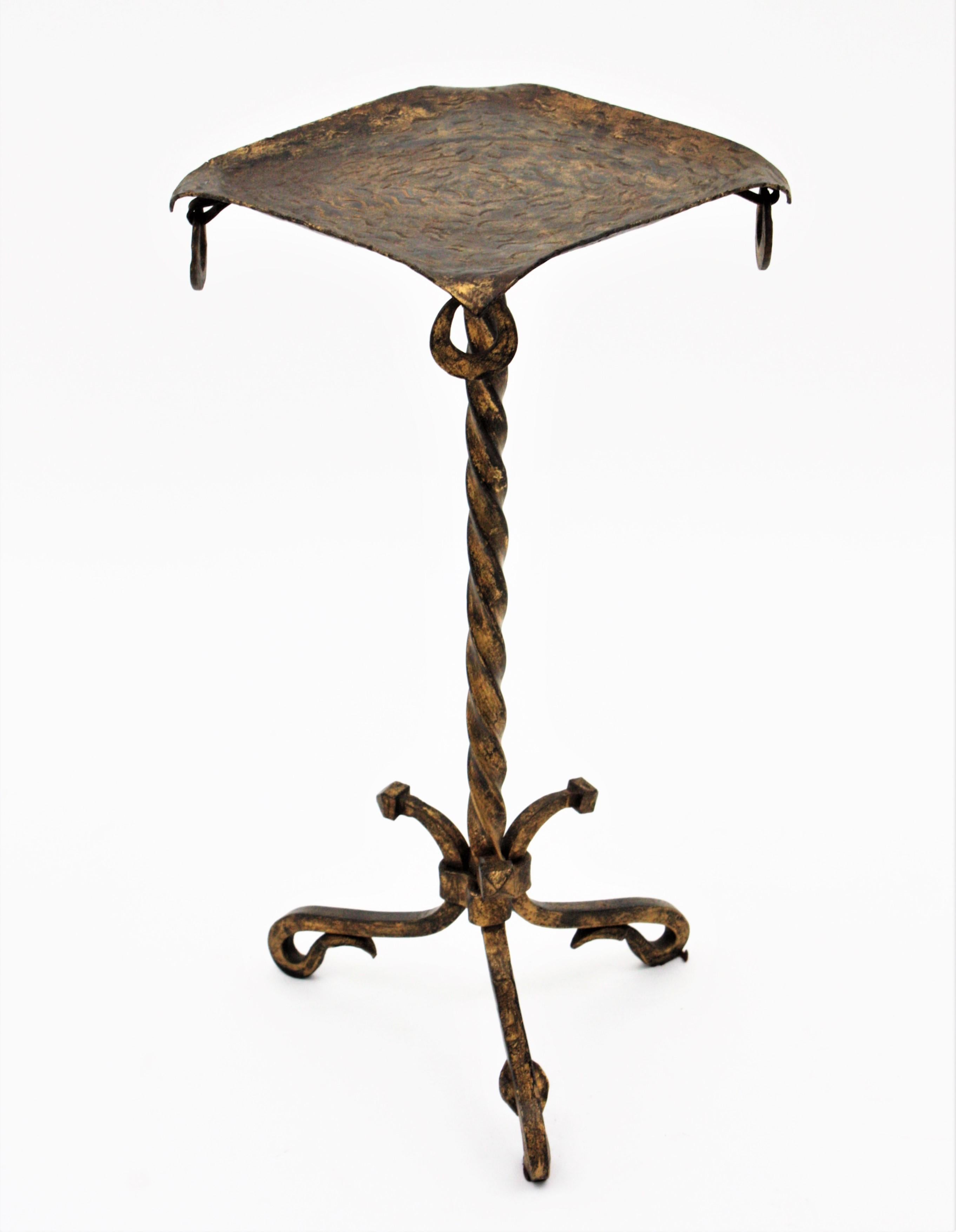 Eye-catching parcel-gilt hand forged side table twisting and ring detail. Spain, 1940s.
This beautiful Martini table features a rhombus top with ring details standing on a tripod base with twisting and scroll details. This table is entirely made by