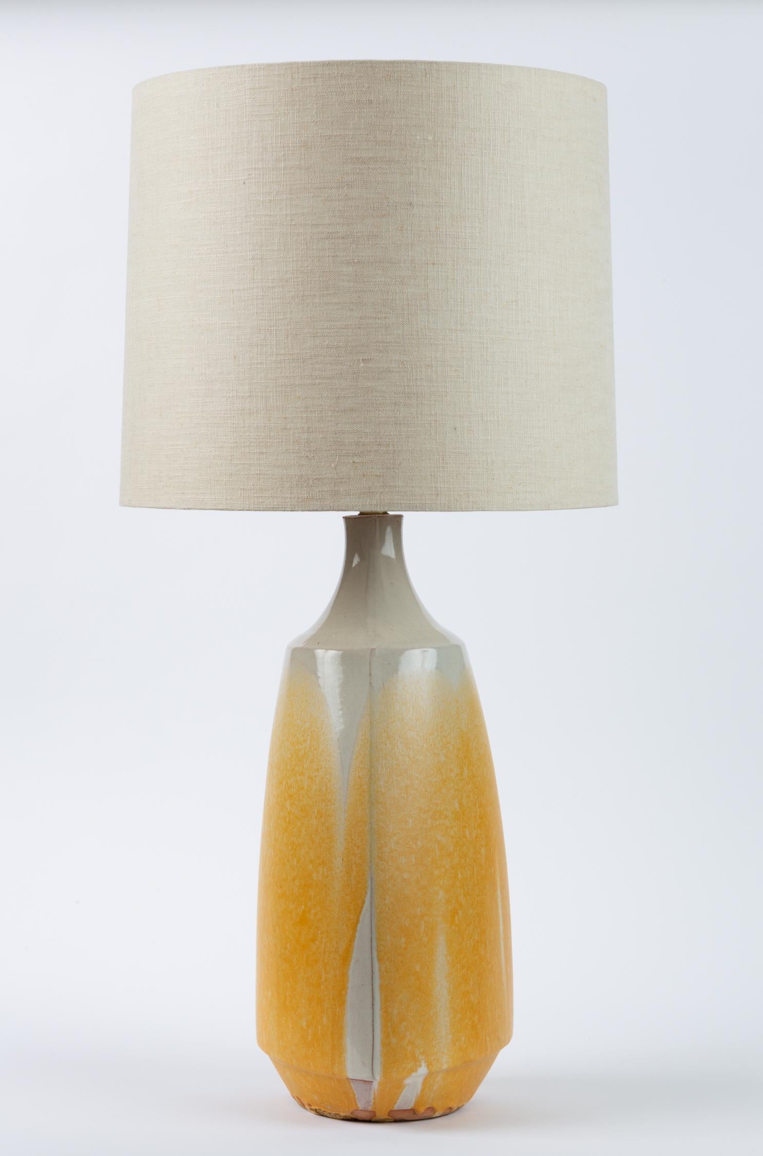Statement lighting by David Cressey in stoneware with three sloping sides and an angular foot. The Studio Pottery-influenced shape of the lamp is emphasized by a white coating of drip glaze, leaving some exposed stoneware near the bottom of the