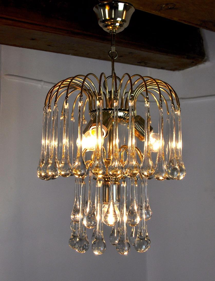 Très beau lustre Venini conçu et produit en Italie dans les années 1970. Lustre en métal doré composé de verres en forme de gouttes répartis circulairement sur deux niveaux. Objet design rare qui illuminera merveilleusement votre intérieur.