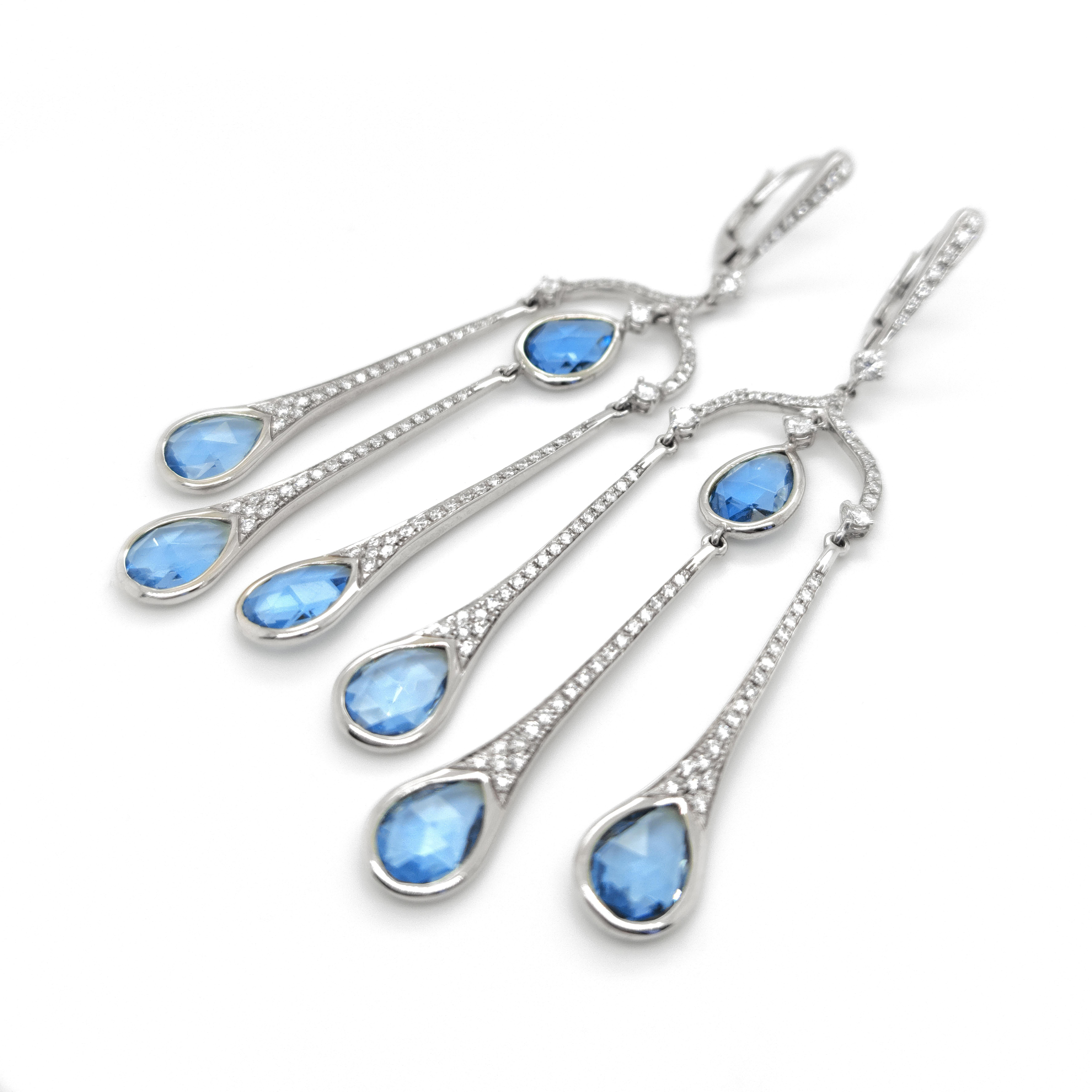 These drop chandelier earrings are a stunning combination of diamonds and blue topaz. The earrings feature a cascading design with multiple tiers, giving them an elegant and glamorous look. The diamonds are expertly set within the intricate