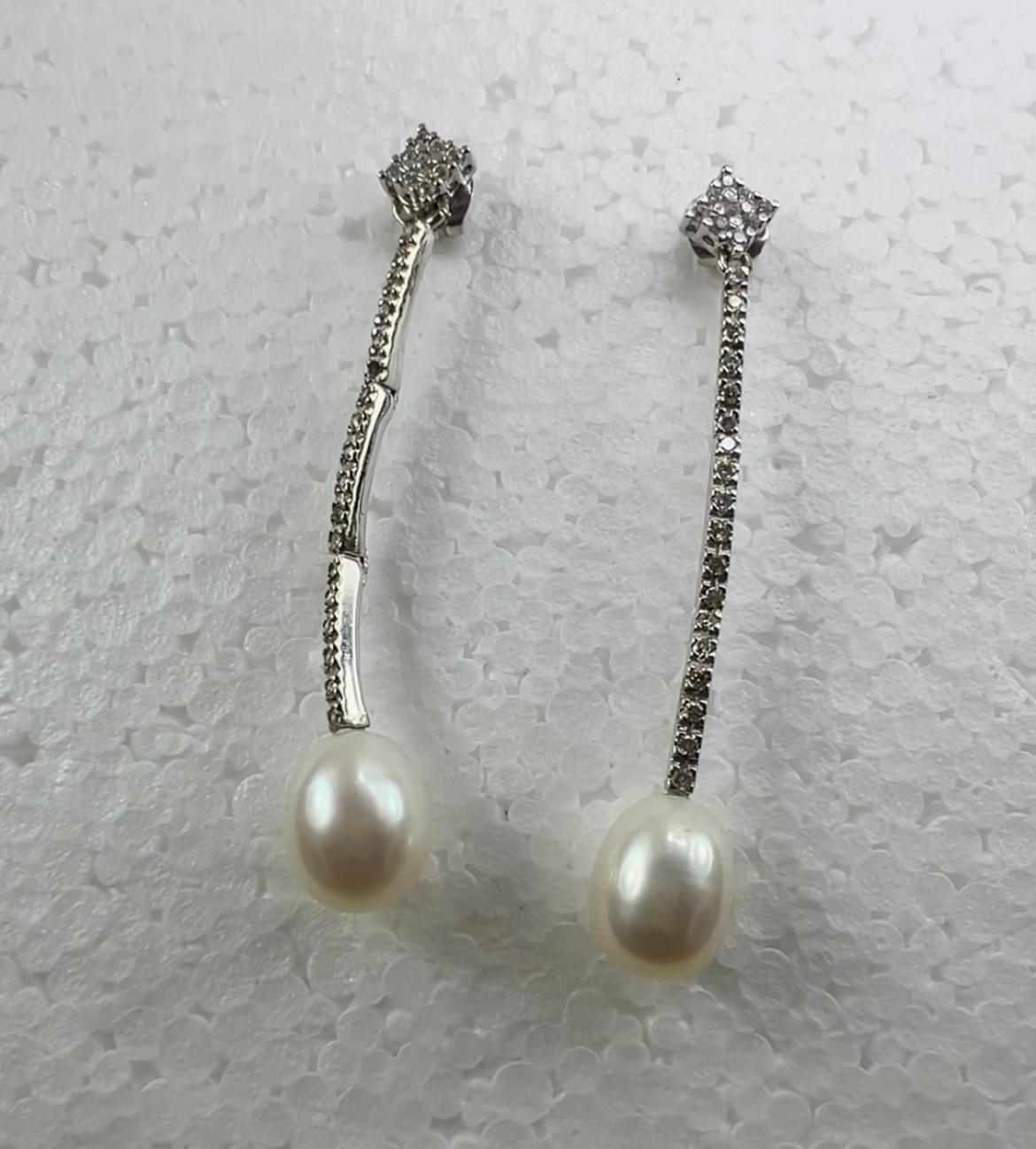 Orecchini a goccia con perla bianca coltivata in oro bianco 18 carati 
e 1,28ct  Pavé di diamanti
Elegantemente realizzato in  Oro bianco 18 carati Questi orecchini a goccia romantici e chic sono costituiti da perle coltivate da 11 mm e da un design