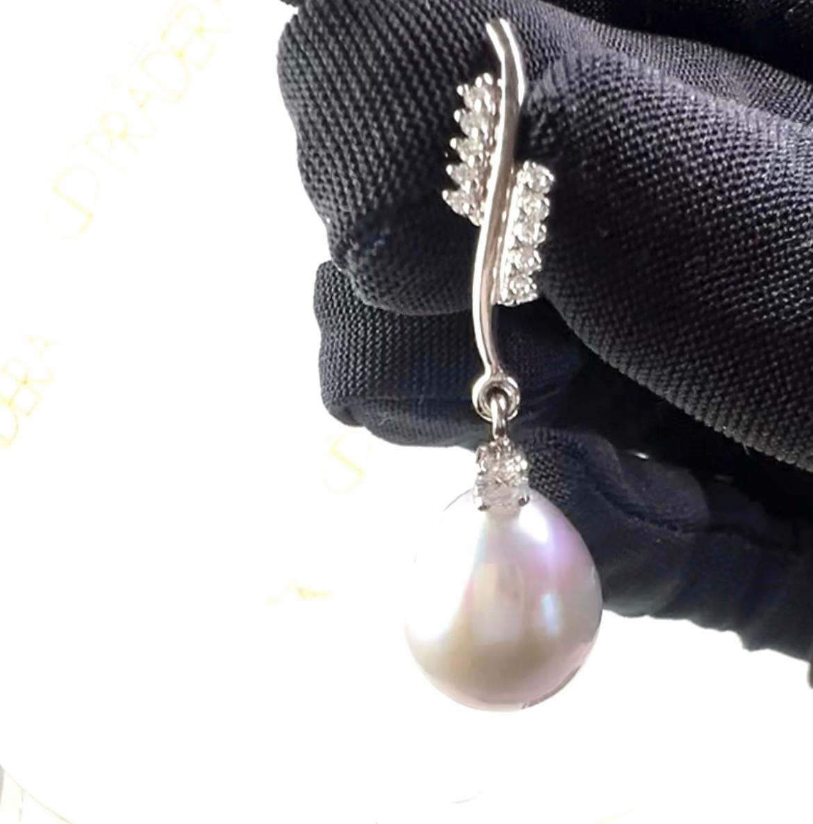 Orecchini a goccia con perla bianca coltivata in oro bianco 18 carati 
e 0,50ct  Pavé di diamanti
Elegantemente realizzato in  Oro bianco 18 carati Questi orecchini a goccia romantici e chic sono costituiti da perle coltivate da 11 mm e da un design