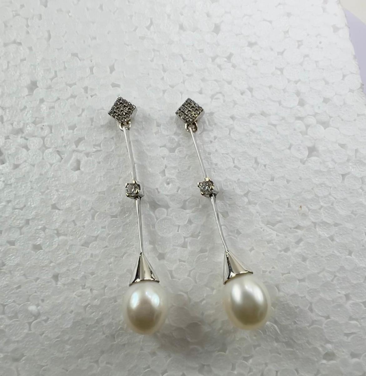 Orecchini a goccia con perla bianca coltivata in oro bianco 18 carati 
e 0,50ct  Pavé di diamanti
Elegantemente realizzato in  Oro bianco 18 carati Questi orecchini a goccia romantici e chic sono costituiti da perle coltivate da 11 mm e da un design