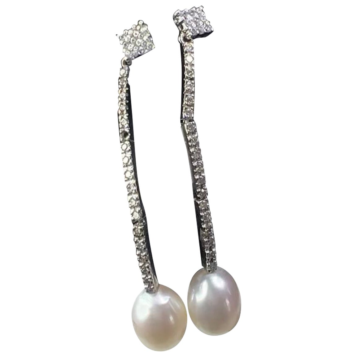 Orecchini a goccia con perla bianca coltivata in oro bianco 18 carati 
e 1,28ct  Pavé di diamanti
Elegantemente realizzato in  Oro bianco 18 carati Questi orecchini a goccia romantici e chic sono costituiti da perle coltivate da 11 mm e da un design