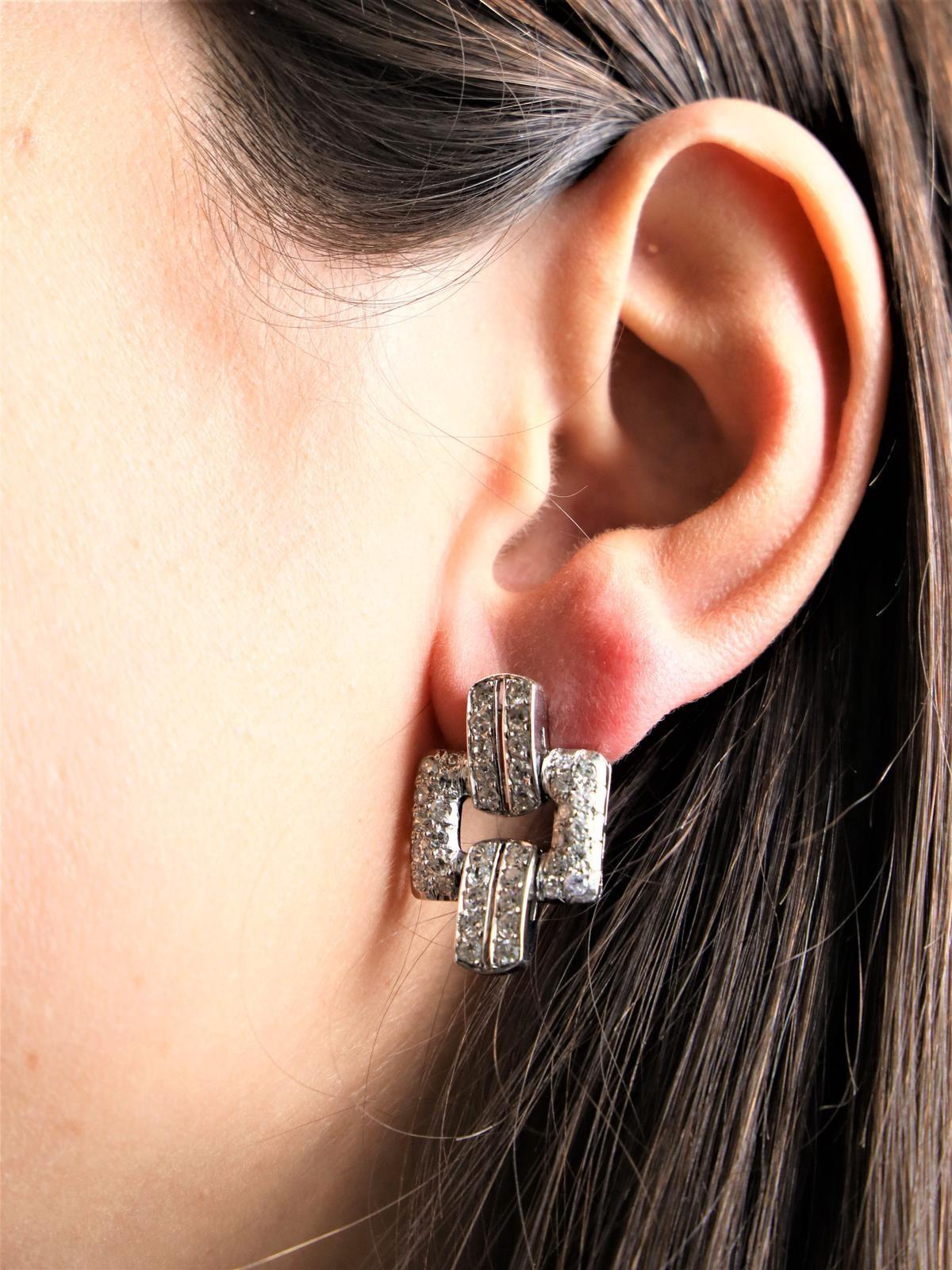 Paire de boucles d'oreilles art déco. en platine 950 millièmes et or blanc 750 millièmes (18 carats). serties de 84 diamants (42 chacun). taille huit/huit. environ 0.04 ct chacune. Poids total des diamants : 3,36 cts. Longueur : 2,55 cm. Largeur :