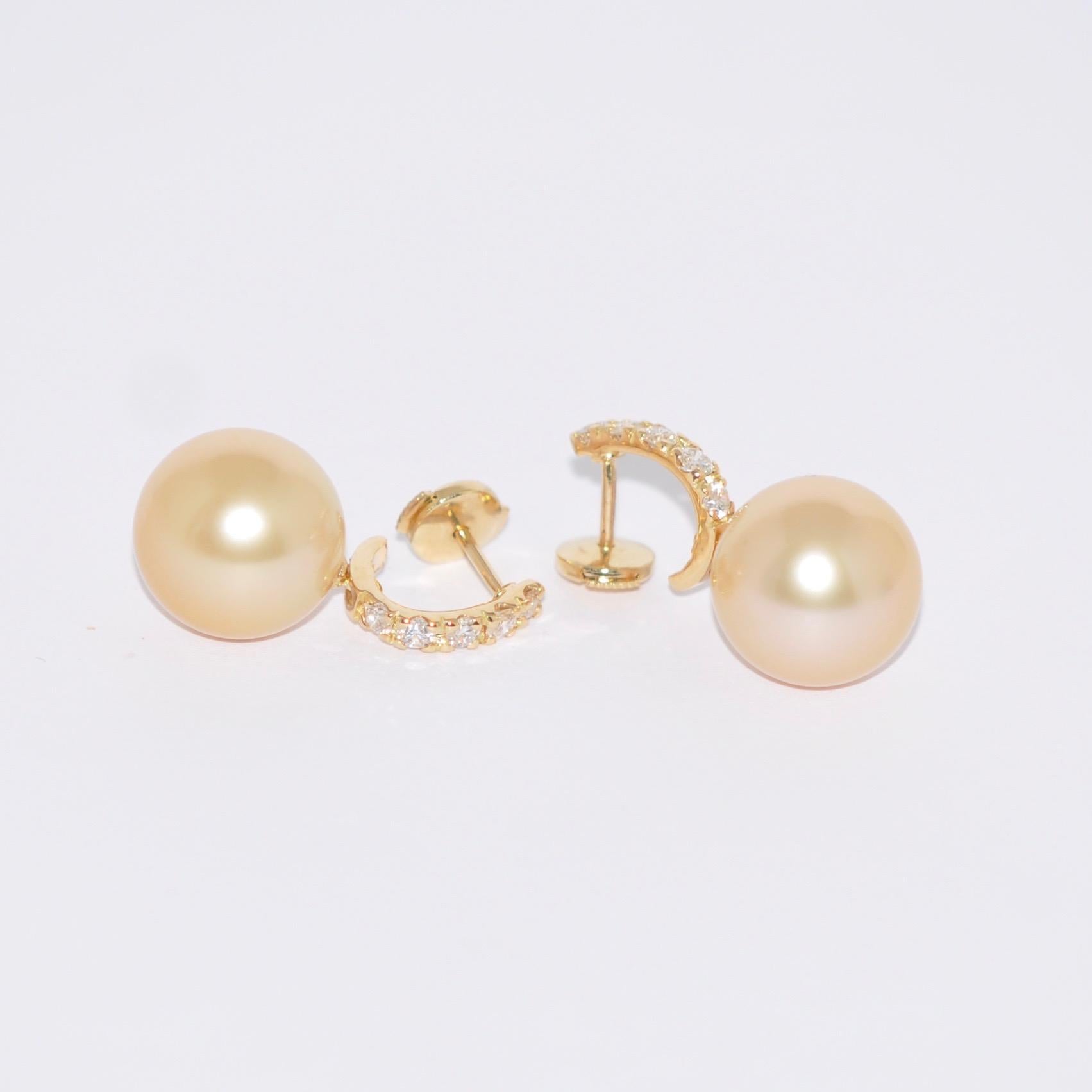 Discover these stunning South Sea pearl and white diamond dangle earrings, meticulously crafted in 18-carat yellow gold. These exquisite jewels evoke classic style and add a touch of glamour to any outfit, whether for a special occasion or simply to