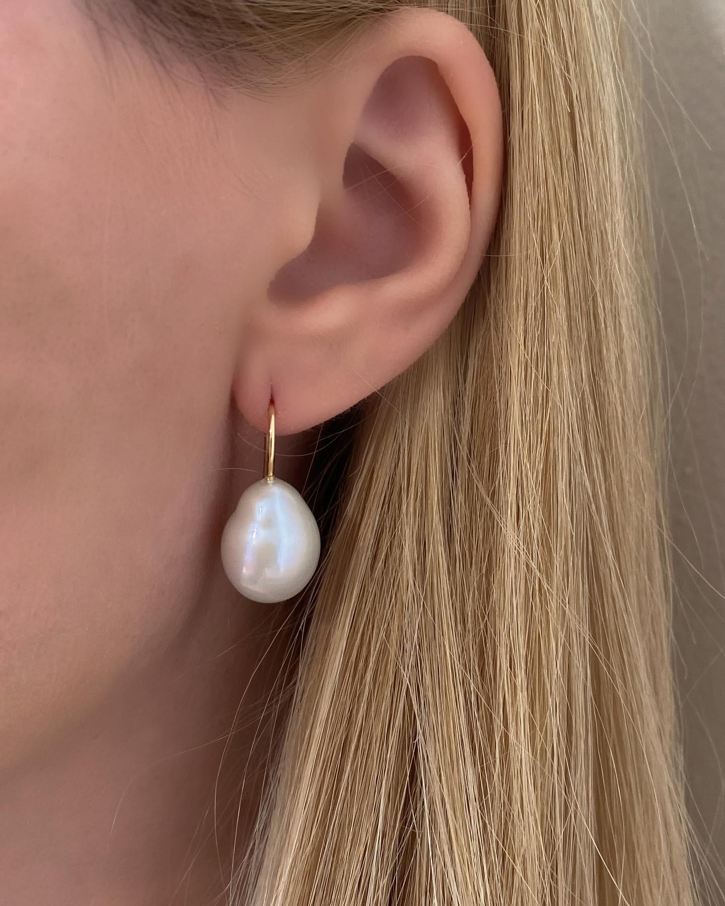 Our Baroque Drop Pearl Earrings are a best seller in our collection. This pair of earrings features baroque, drop shape pearls and a slim 18K Yellow Gold hook design that slips on to the ear. They are easy to slip on and comfortable to wear all day