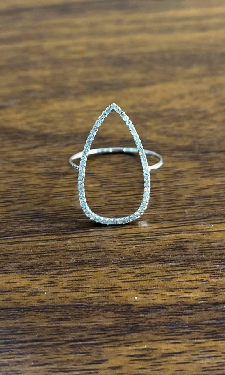 This elegant piece features a delicate open teardrop design. The teardrop is adorned with a series of small, sparkling diamonds that catch the light beautifully. The minimalist band is slender and polished, providing a subtle yet sophisticated
