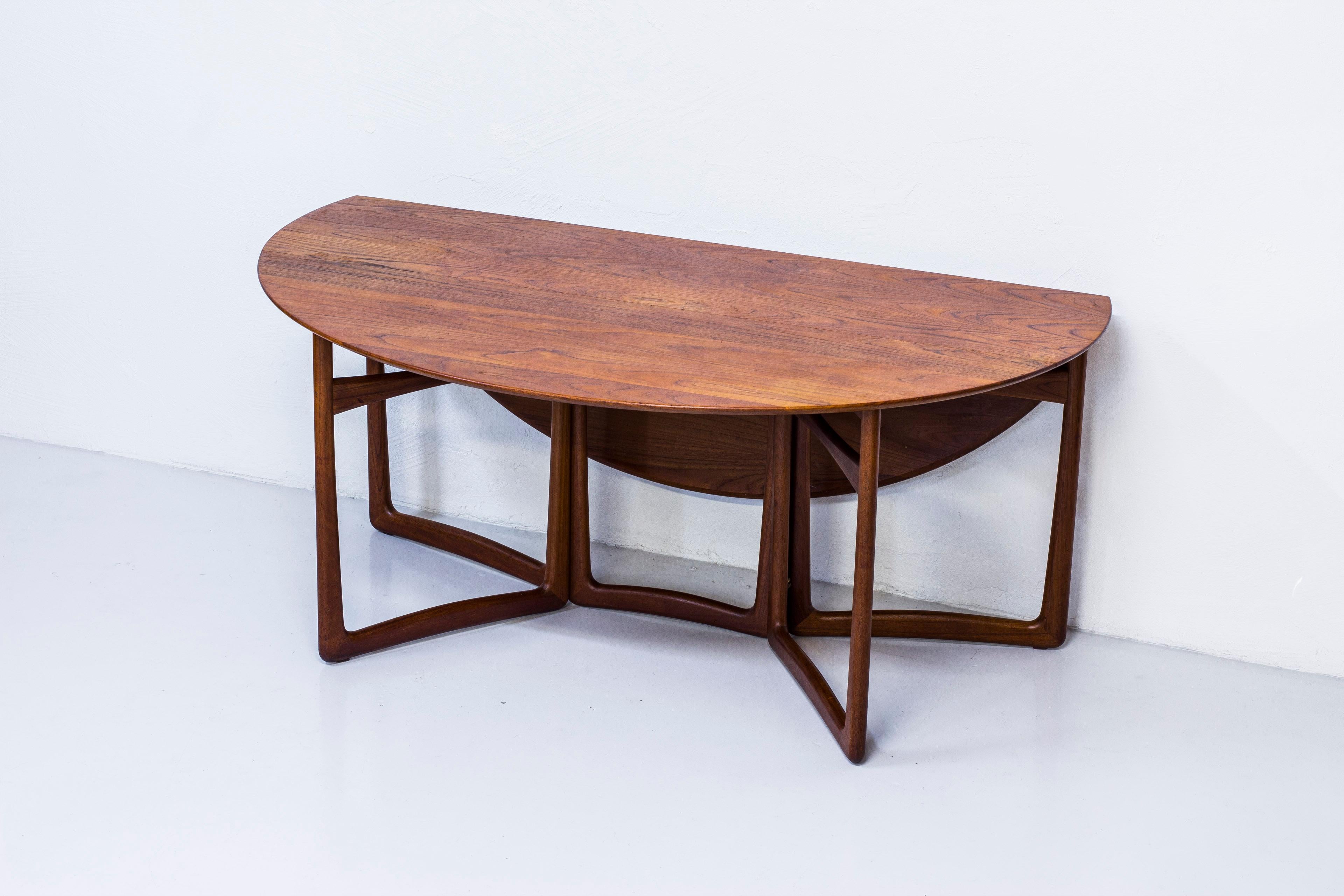 Drop leaf dining table designed by Peter Hvidt & Orla Mølgaard Nielsen. produced by France & Søn in Denmark during the 1950s. Made entirely from solid teak wood with brass details. Very good vintage condition with signs of age related use and light