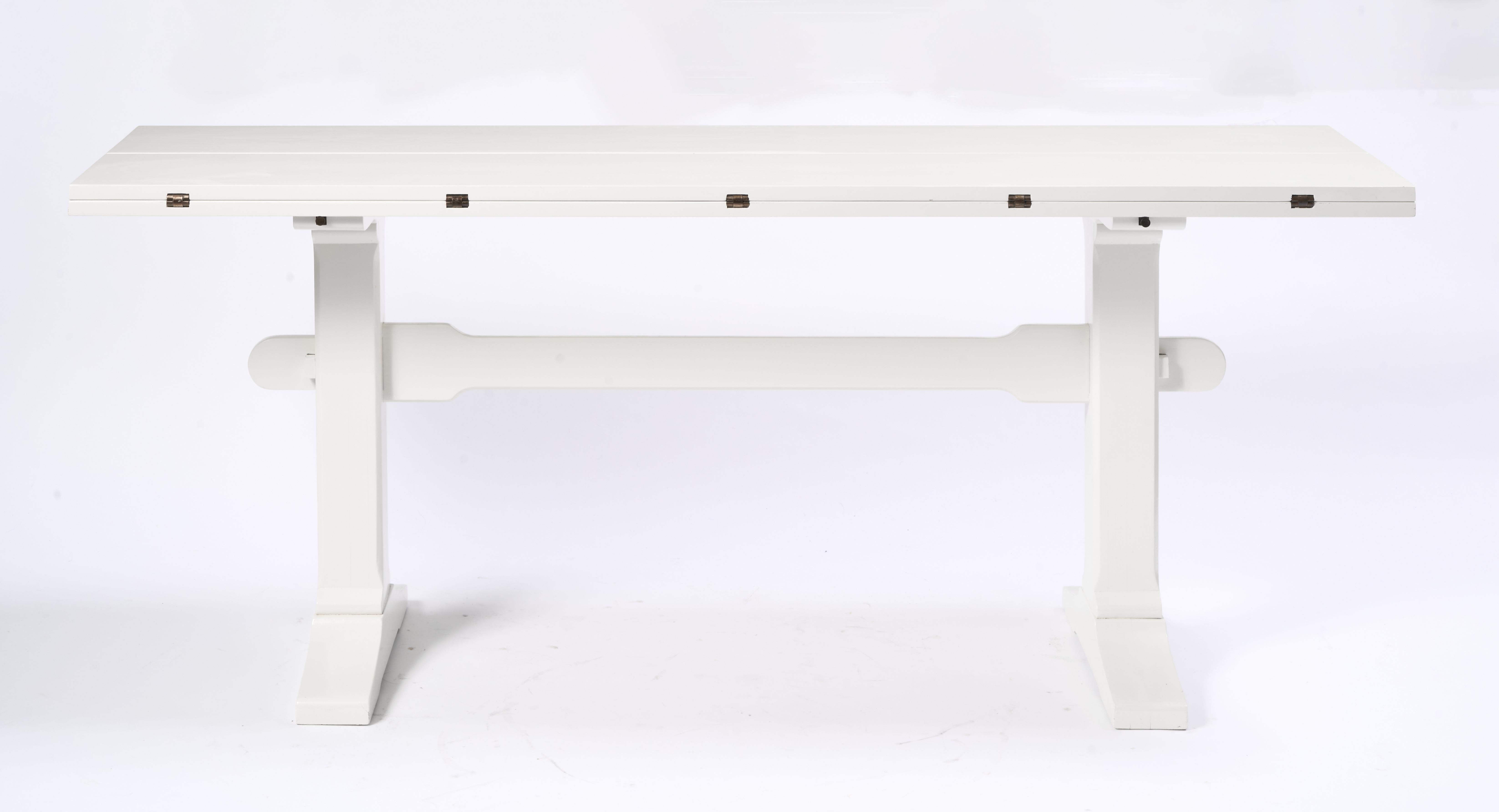 Drop Leaf Library Trestle Table, Cream Lacquer over Solid Oak.

Table shows some minor scuffs to paint, overall great condition. 
Solid brass supports slide out to support table top as it is extended to full depth. Great design allows for