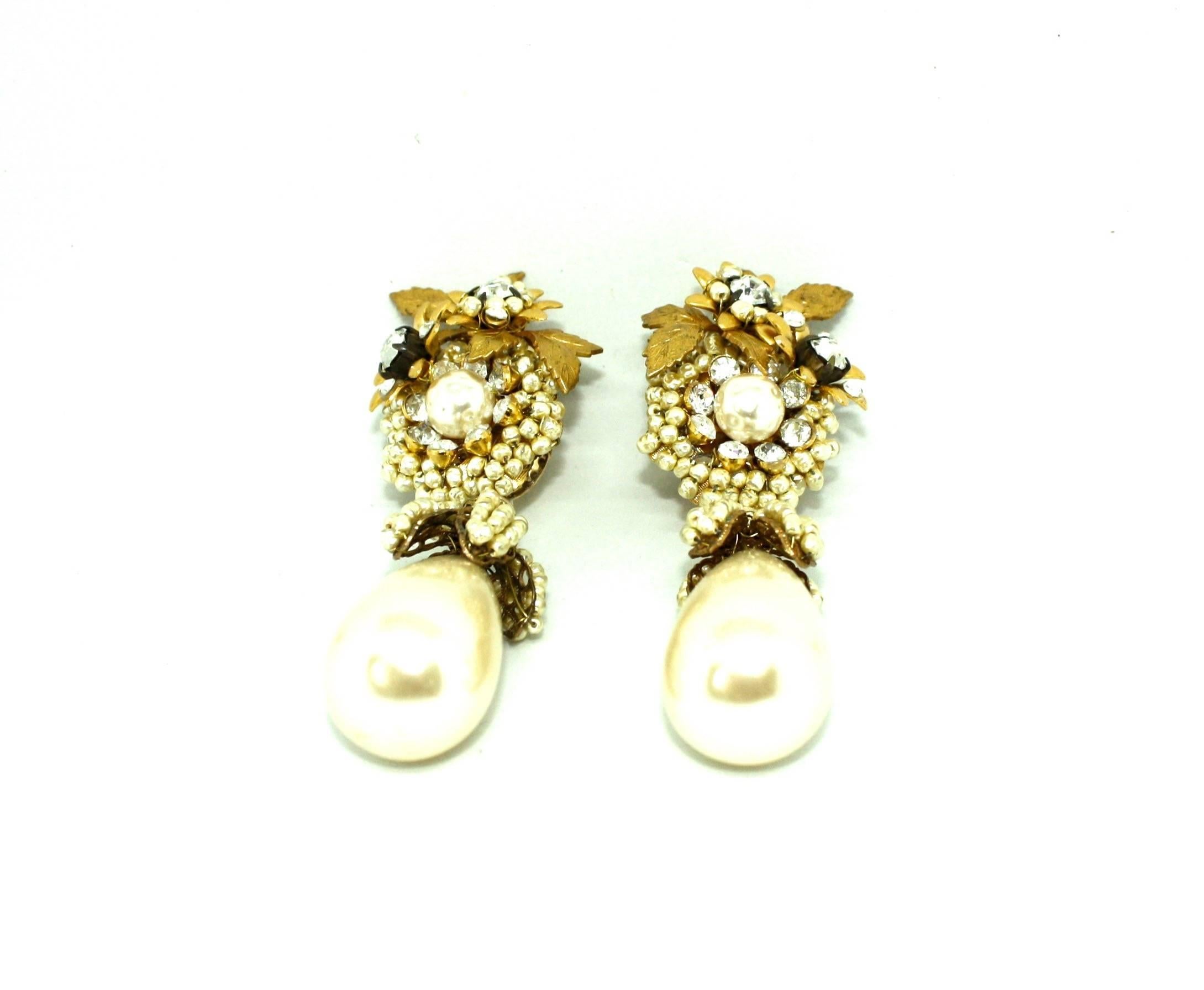 Amazing drop faux pearl clips earrings by former Miriam Haskell designer Larry Vrba. These stunning clip earrings are extremely detailed, adorned with clusters of faux pearls and white diamante stones in a floral theme, ending with a large
