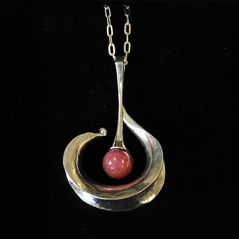 A really nice and drop shaped silver pendant necklace designed by Eric Scott Robbert, Trosa Kvarn. Sweden 1960s.Classic drop design with a pearlround pinkred Thulite stone in the center. Very good vintage condition.
Size: Chain (double) about 30