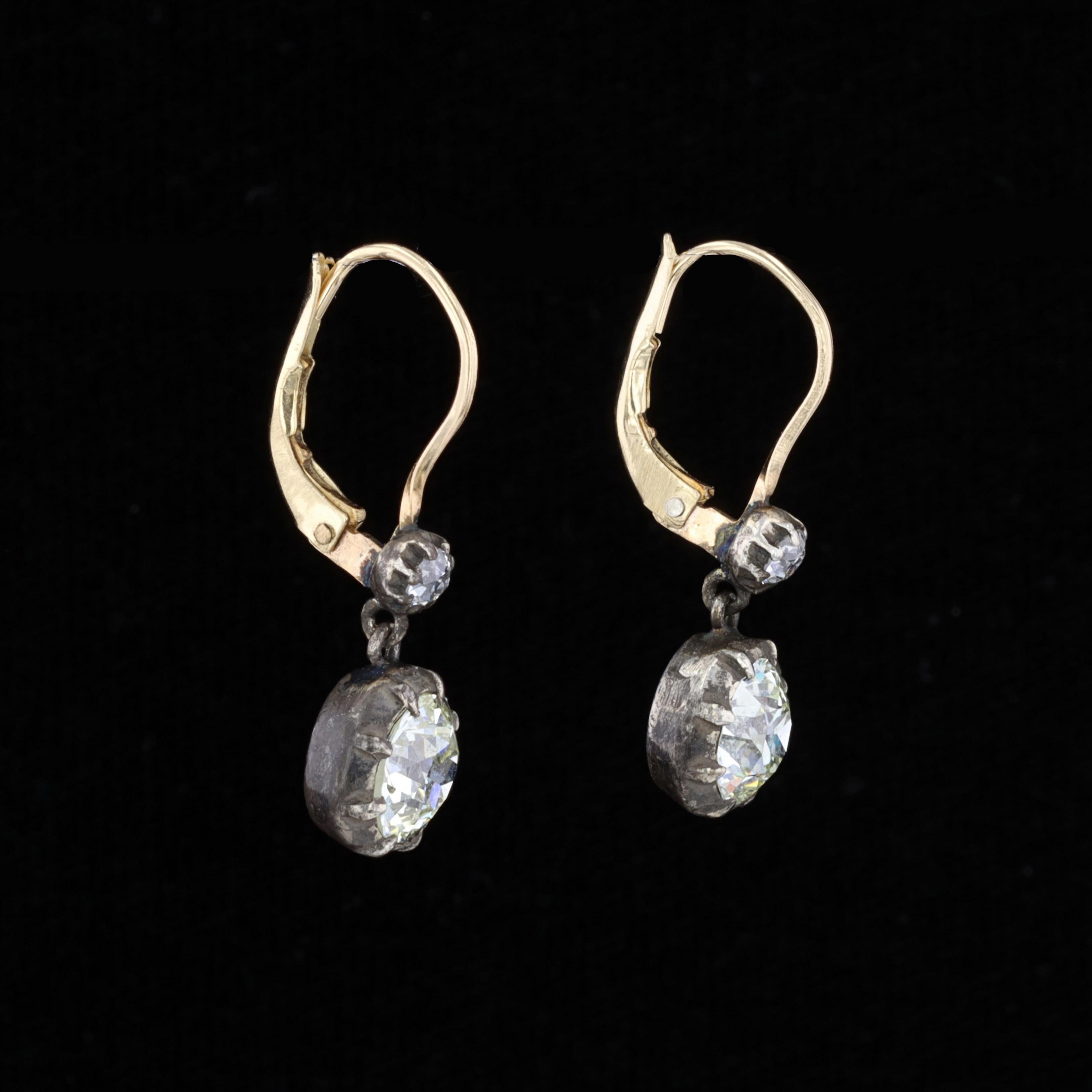 Treasures from the past that are perfect for the present. These vintage silver and gold drop style earrings feature sparkling old mine cut diamonds that weigh approximately 2.69ct. The color of these diamonds is L-M with VS1 clarity. These diamonds