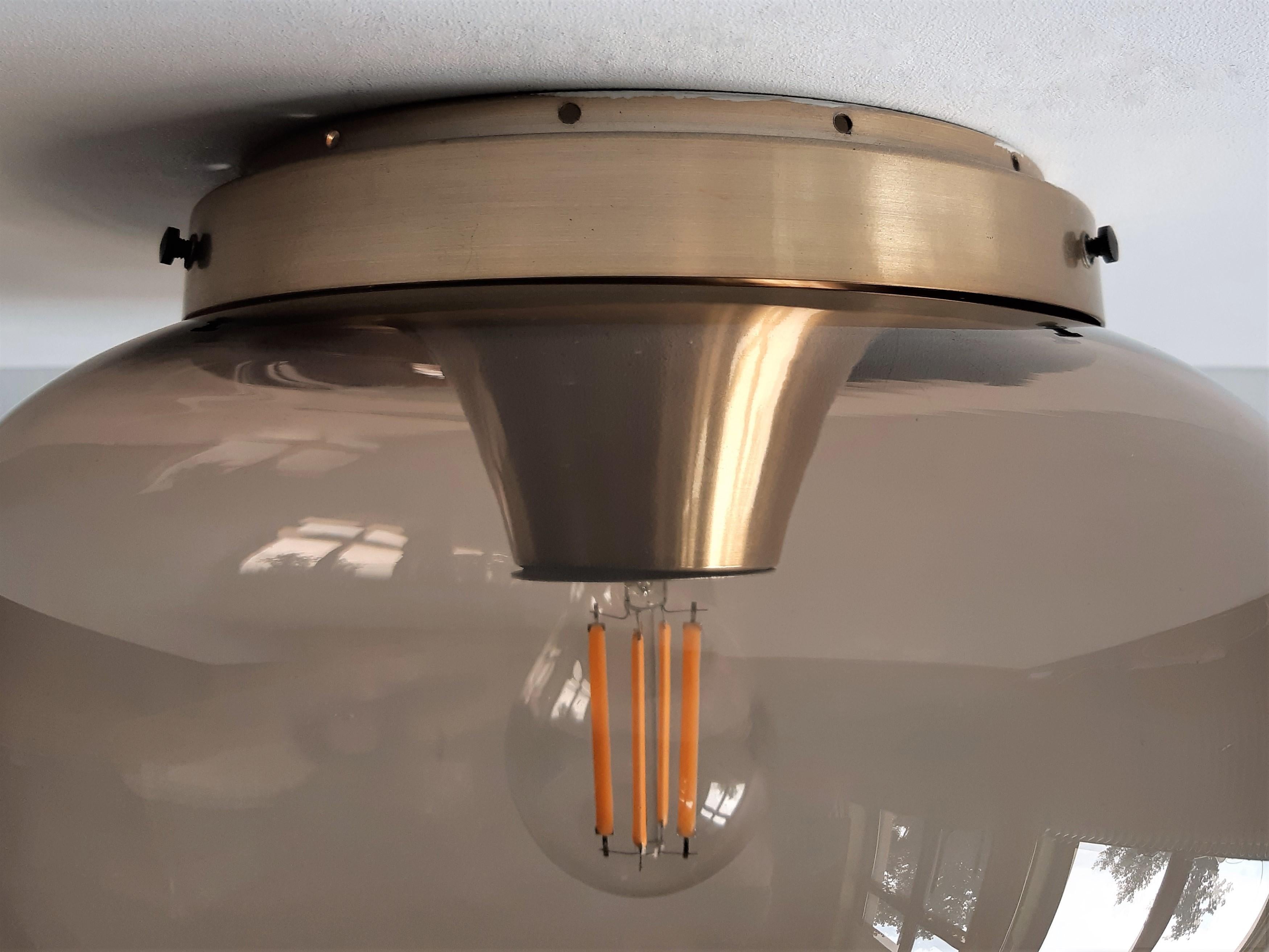 This elegant ceiling lamp or flushmount was made by the Dutch lamp manufacturer Dijkstra in the 1960's/1970's. It has a hand blown smoked glass lampshade. Because of its shape it is often called 'druppel' or in English 'Drop'/ 'Droplet'. The round