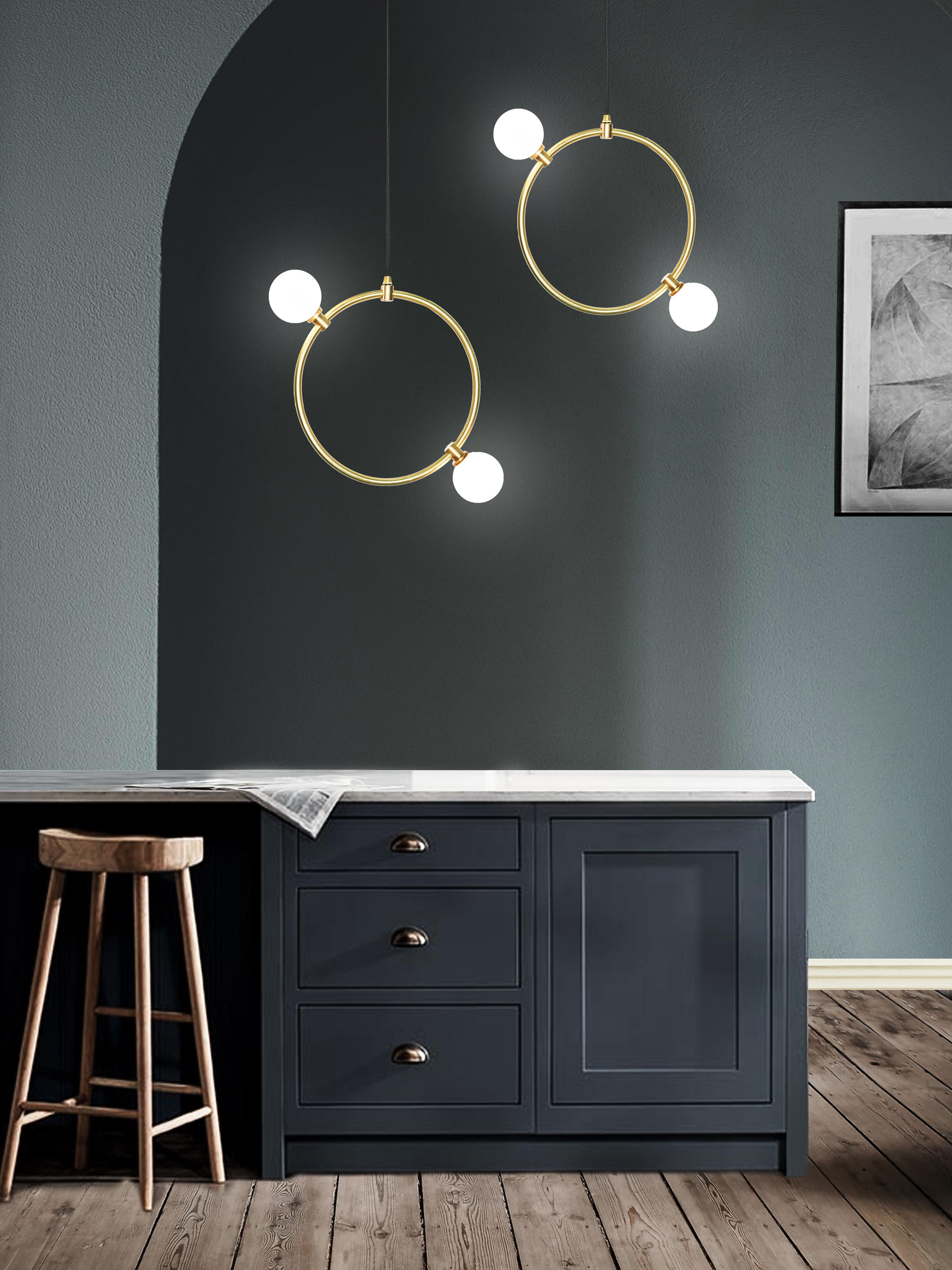 A decorative lighting feature inspired by the notion of light cascading through open space. The modular collection is comprised of whitened crystal glass orbs, fastened to delicate brass rings. 

The rings can be hung as singular pieces or in