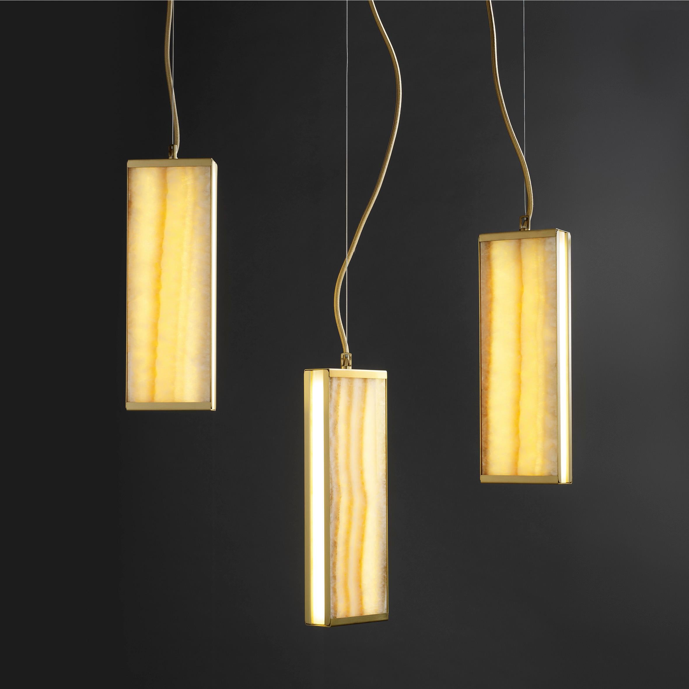 The drops suspension, composed of three adjustable modules placed vertically, creates a decisive stain of color, thanks to the warm tonality of the backlit onyx. At the same time, the white light side bars offer diffused illumination of the