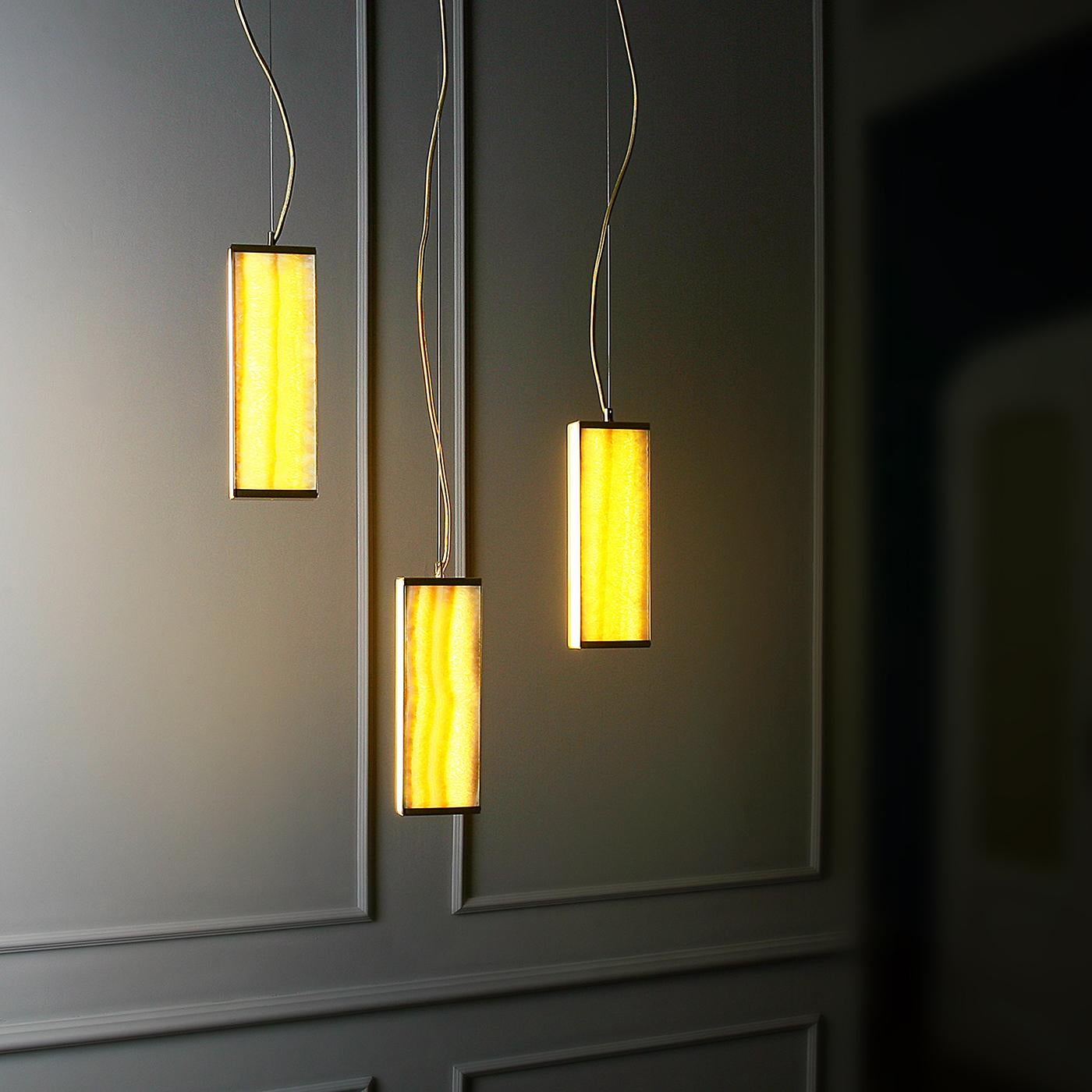 Tre moduli regolabili creano questa elegante lampada a sospensione. Aggiungendo un elegante senso di movimento e un tocco di colore agli interni contemporanei, ogni diffusore in onice senape con dettagli in nichel nero è retroilluminato per