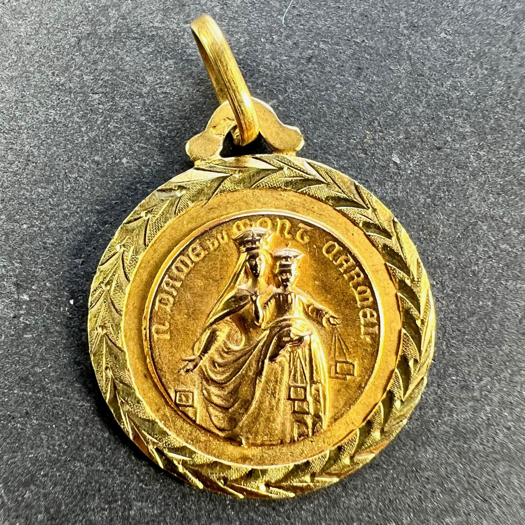 A French 18 karat (18K) yellow gold charm pendant designed as a medal depicting the Madonna and Child holding a pair of devotional scapulars, with the phrase N. (Notre) Dame du Mont Carmel surrounding them. The other side depicts Jesus Christ with
