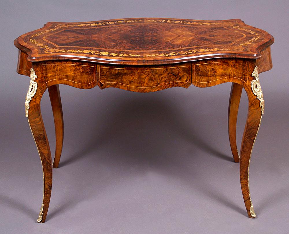 Druce & Co inlaid writing table, London, circa 1900
An inlaid writing table with a wavy skeleton, supported on four S-shaped bent legs. At the top, a table top, slightly protruding beyond the outline of the furniture, with two inserts of diagonally