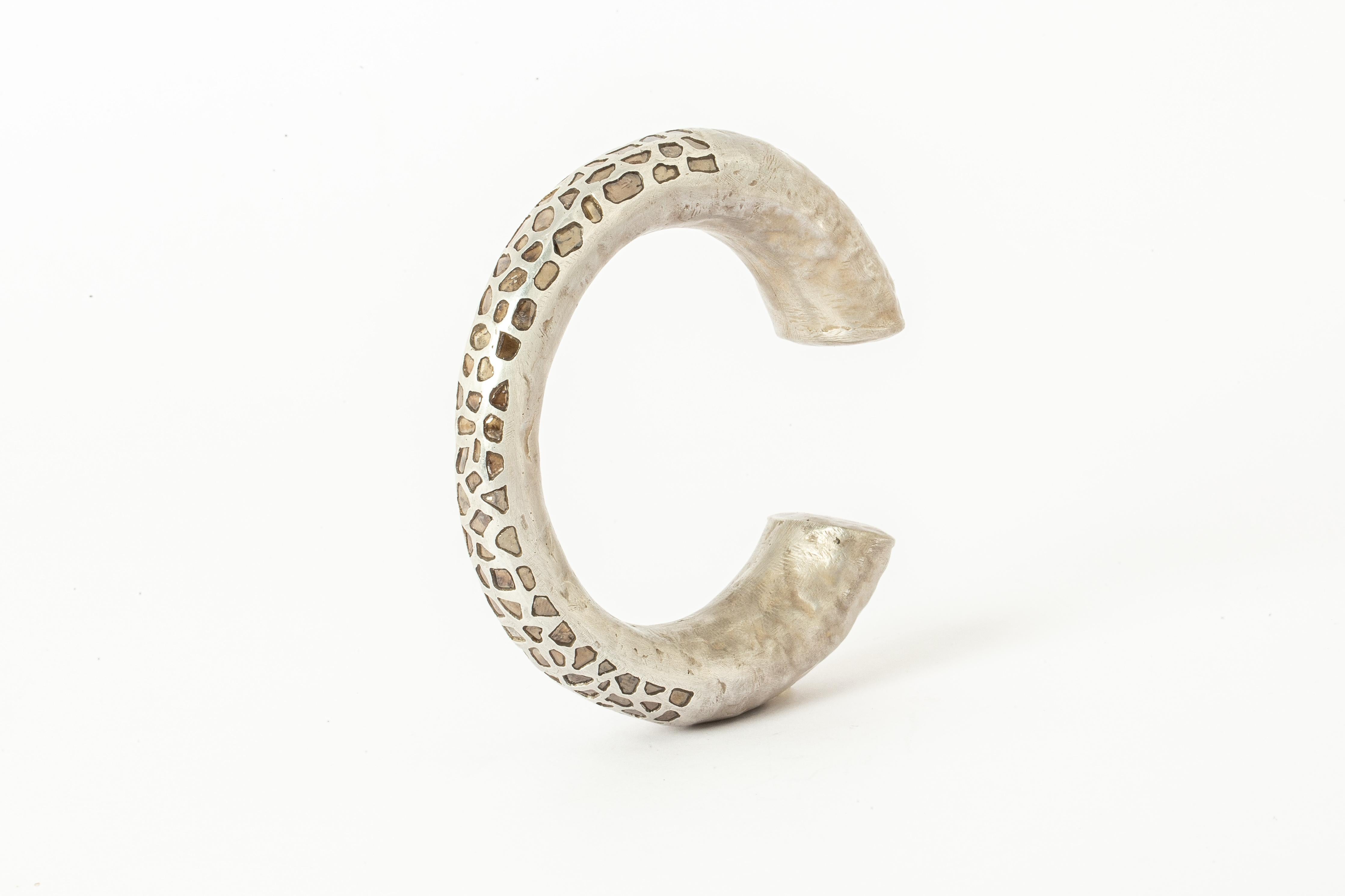 Bracelet in acid treated sterling silver and slabs of rough diamond set in mega pave setting. These slabs are removed from a larger chunk of diamond. This item is made with a naturally occurring element and will vary from the photograph you see.