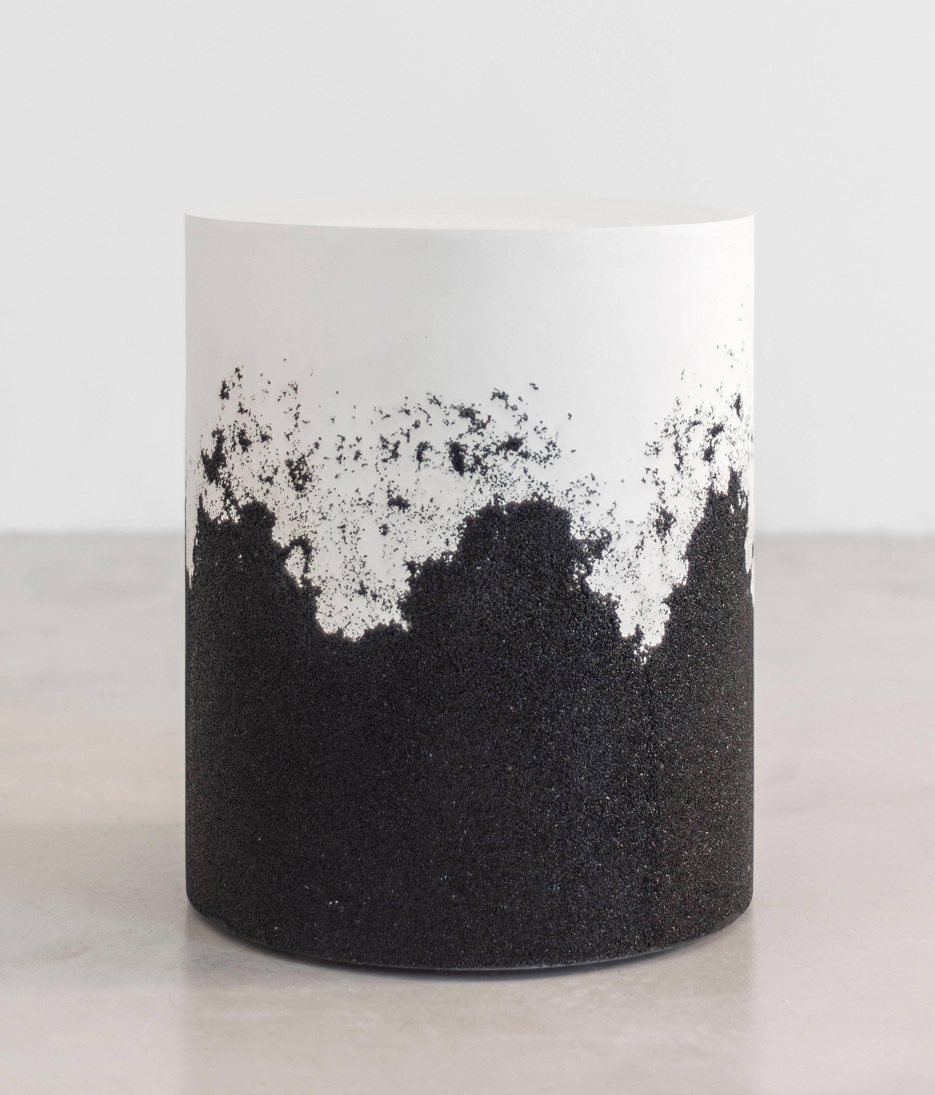 A layering of cement and crushed aggregates, the made-to-order drum consists of an hand-dyed white cement top and a packed black silica bottom. Poured by hand over the jagged minerals, the white cement merges the materials to create a unique organic