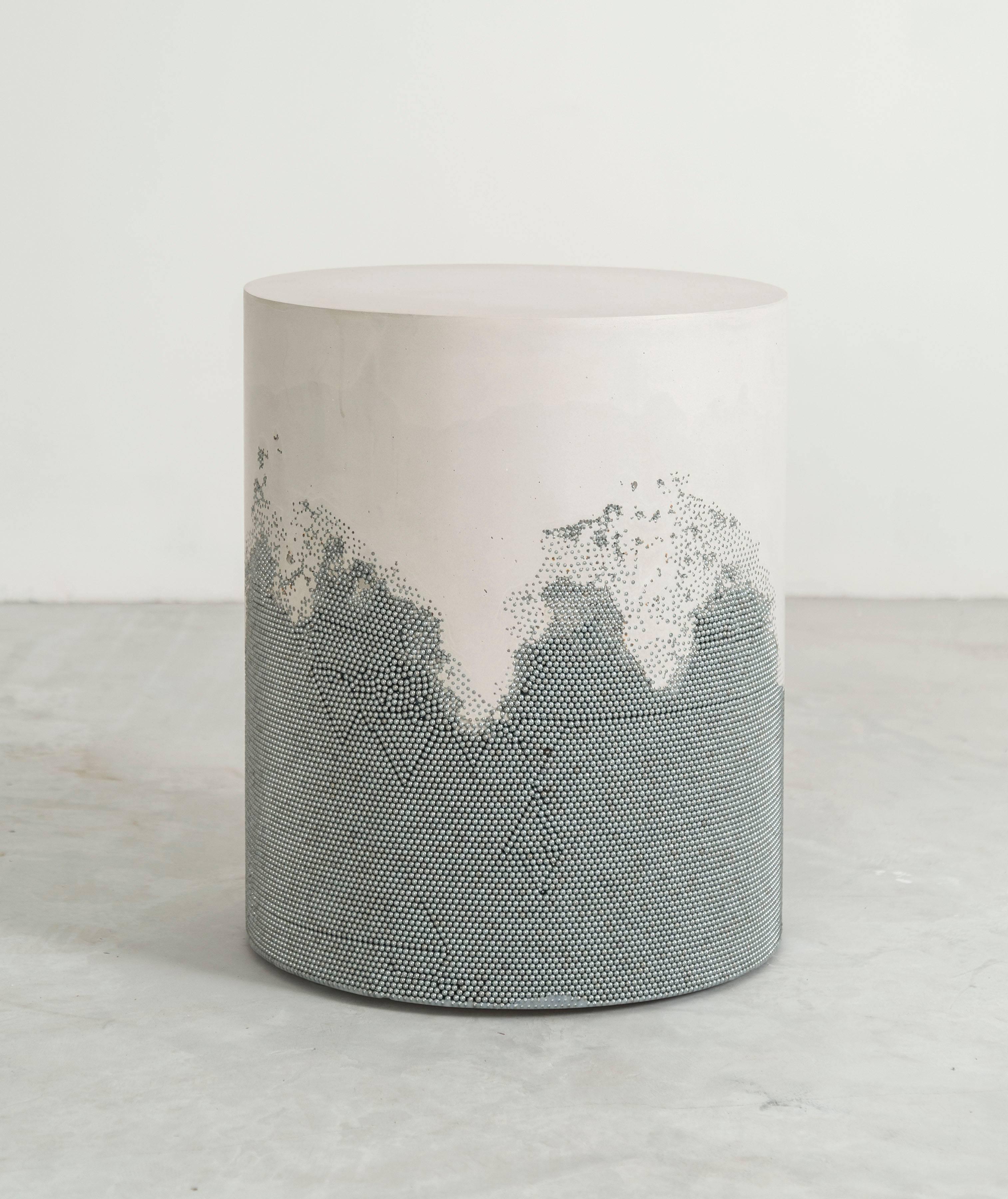 A layering of cement and crushed aggregates, the made-to-order drum consists of an hand-dyed white cement top and a packed silver bb bottom. Poured by hand over the silver pellets, the white cement merges the materials to create a unique organic