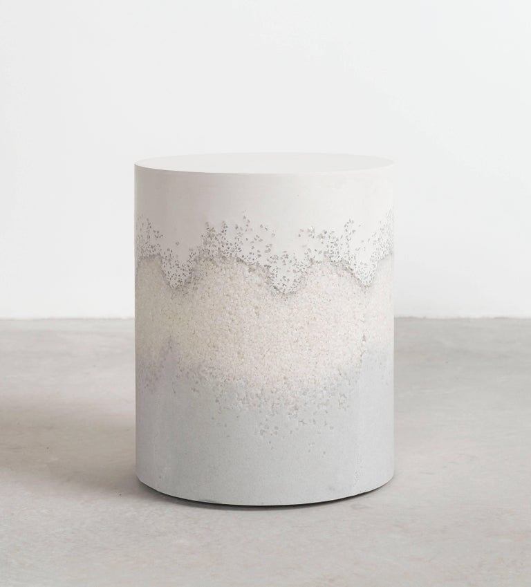 A layering of cement and crushed aggregates, the made-to-order drum consists of a hand-dyed white cement top and a packed crystal quartz center and powdered glass bottom. Poured by hand over the jagged granules, the white cement combines the