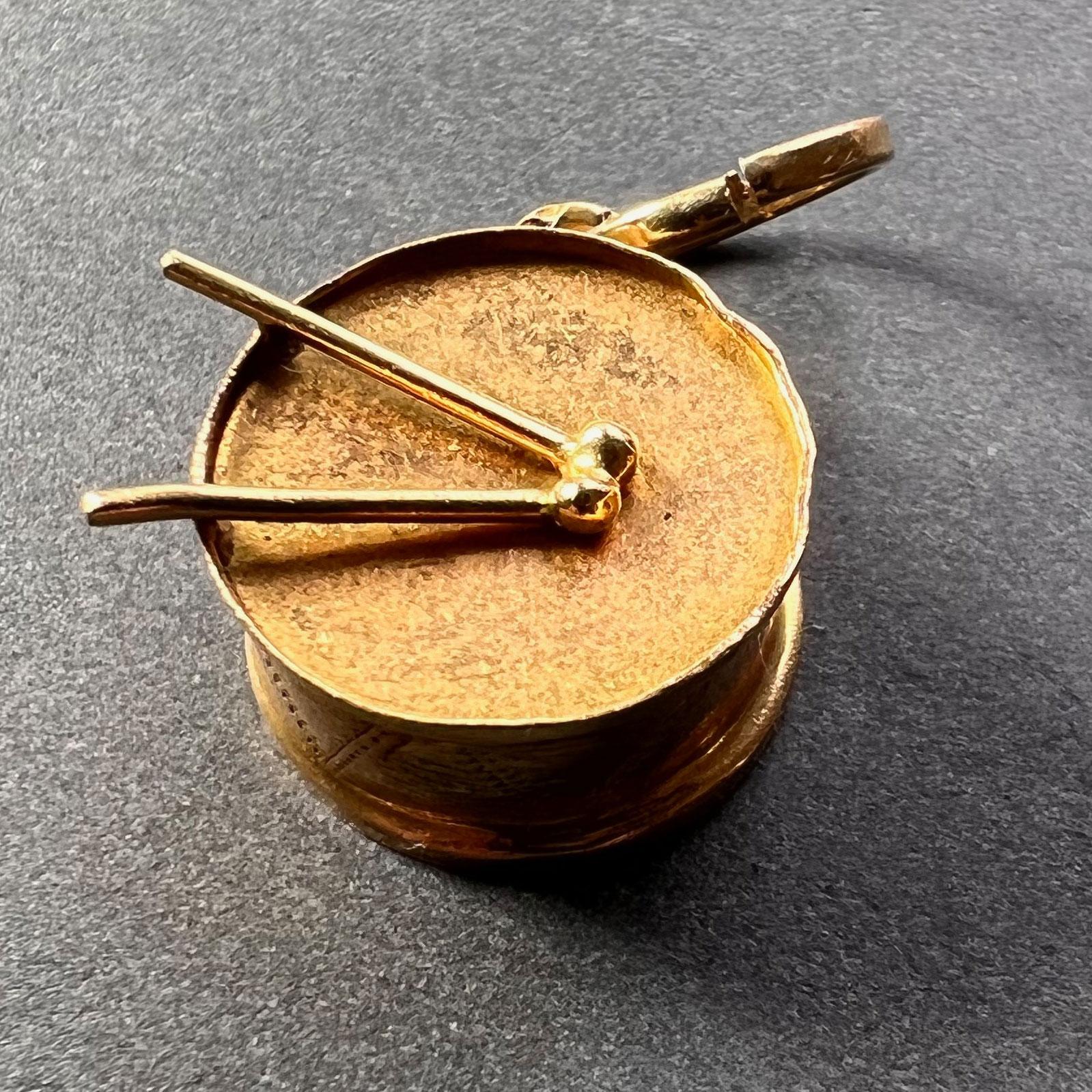 Un pendentif de charme en or jaune 18 carats (18K) conçu comme un tambour. Estampillé 750 pour de l'or 18 carats sur l'anse.
 
Dimensions : 1.7 x 1,6 x 0,7 cm (sans l'anneau)
Poids : 2,20 grammes
