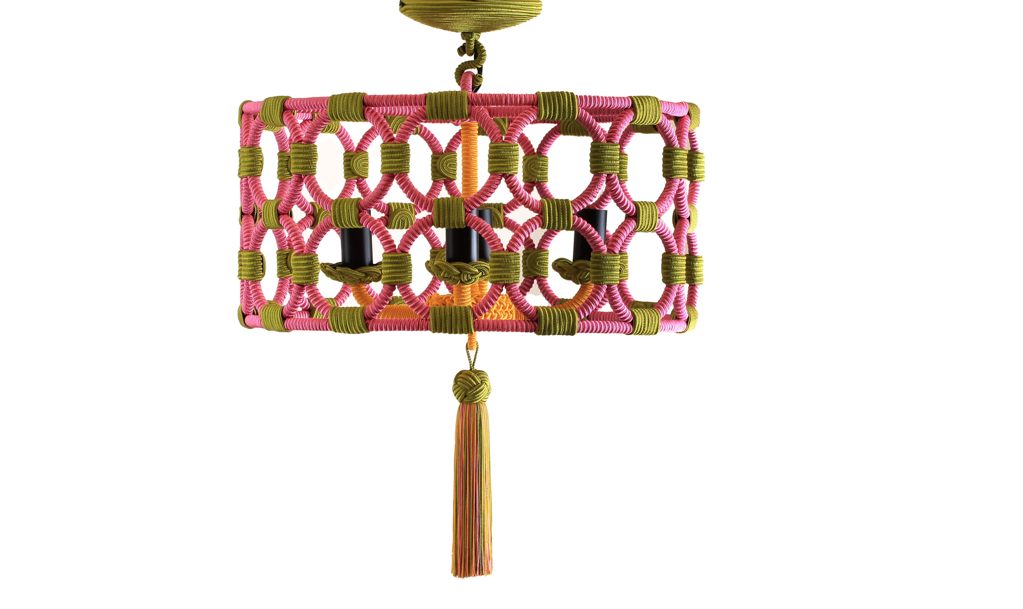The four armed candle light fixture is enclosed by a wrought iron drum structure made of a multitude of rings, wrapped and attached with our traditional silk passementerie, resulting in a sleek contemporary pendant. Custom sizes and finishes