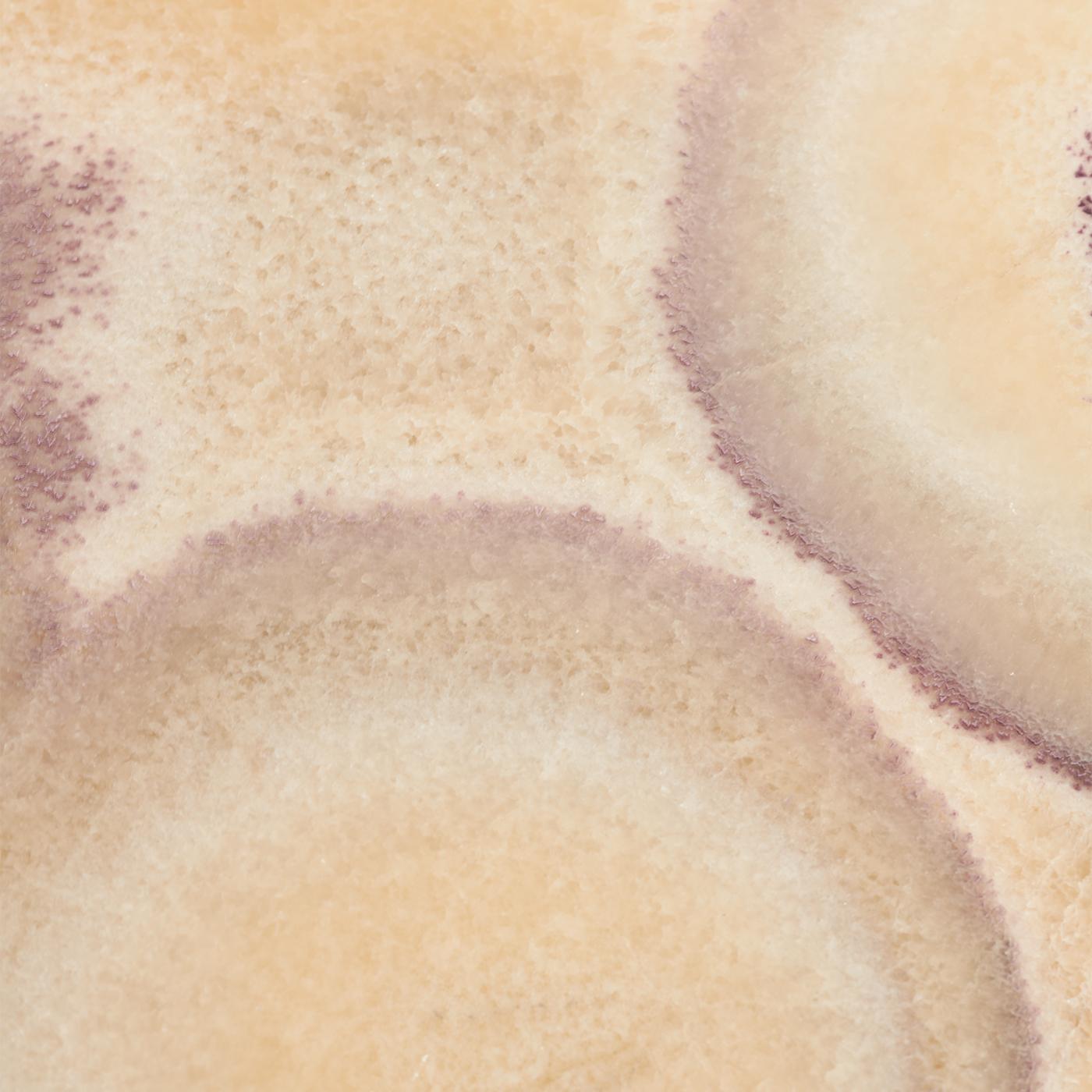 Der Drum Couchtisch ist eine atemberaubende Verschmelzung von Materialien, die Eleganz ausstrahlt. Auf einem massiven, zylindrischen Bronzesockel ruht eine auffällige Platte aus 