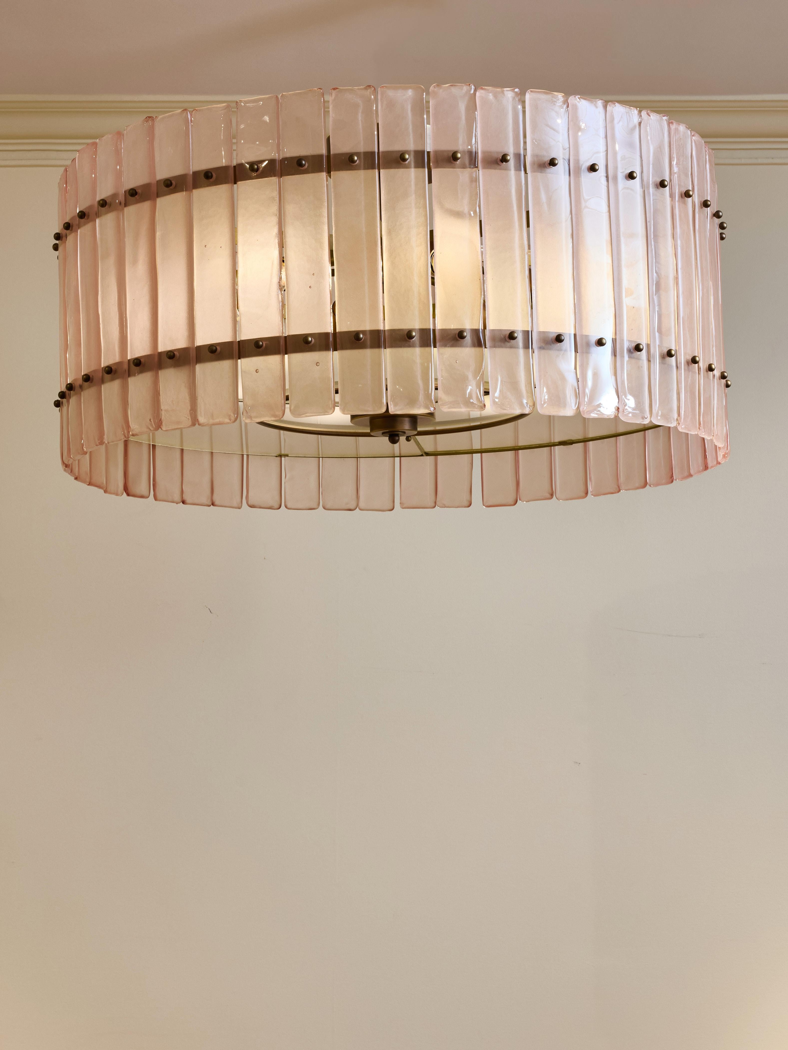 Lampadario circolare in ottone patinato e lastre di vetro rosa di Murano.
Creazione dello Studio Glustin.