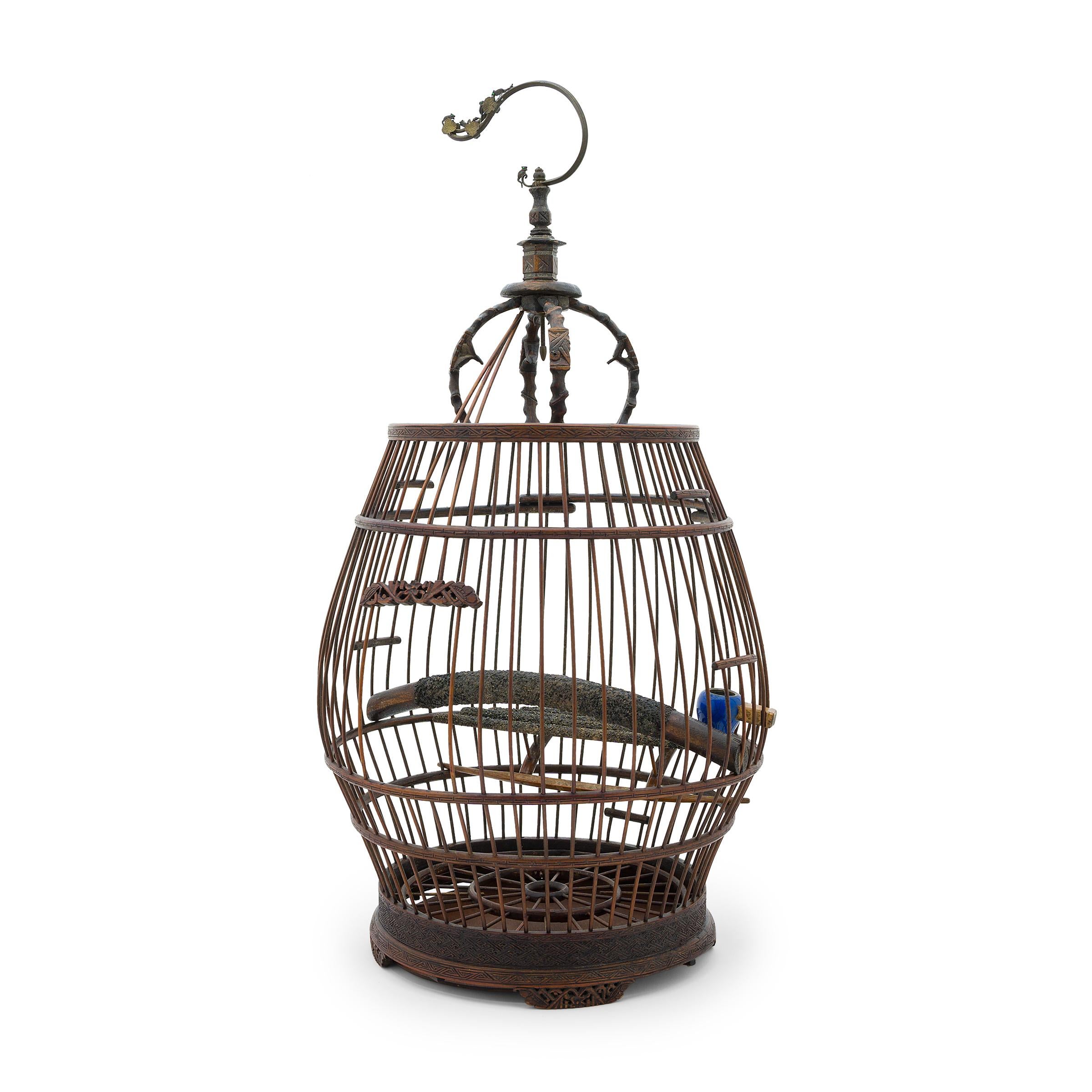This delicate wooden birdcage was once home to the tiny pet bird of a Qing-dynasty aristocrat. Dated to the mid-19th century, this drum-shaped cage is carefully assembled of thin bamboo rods and bent bamboo strips carved with geometric scrollwork.