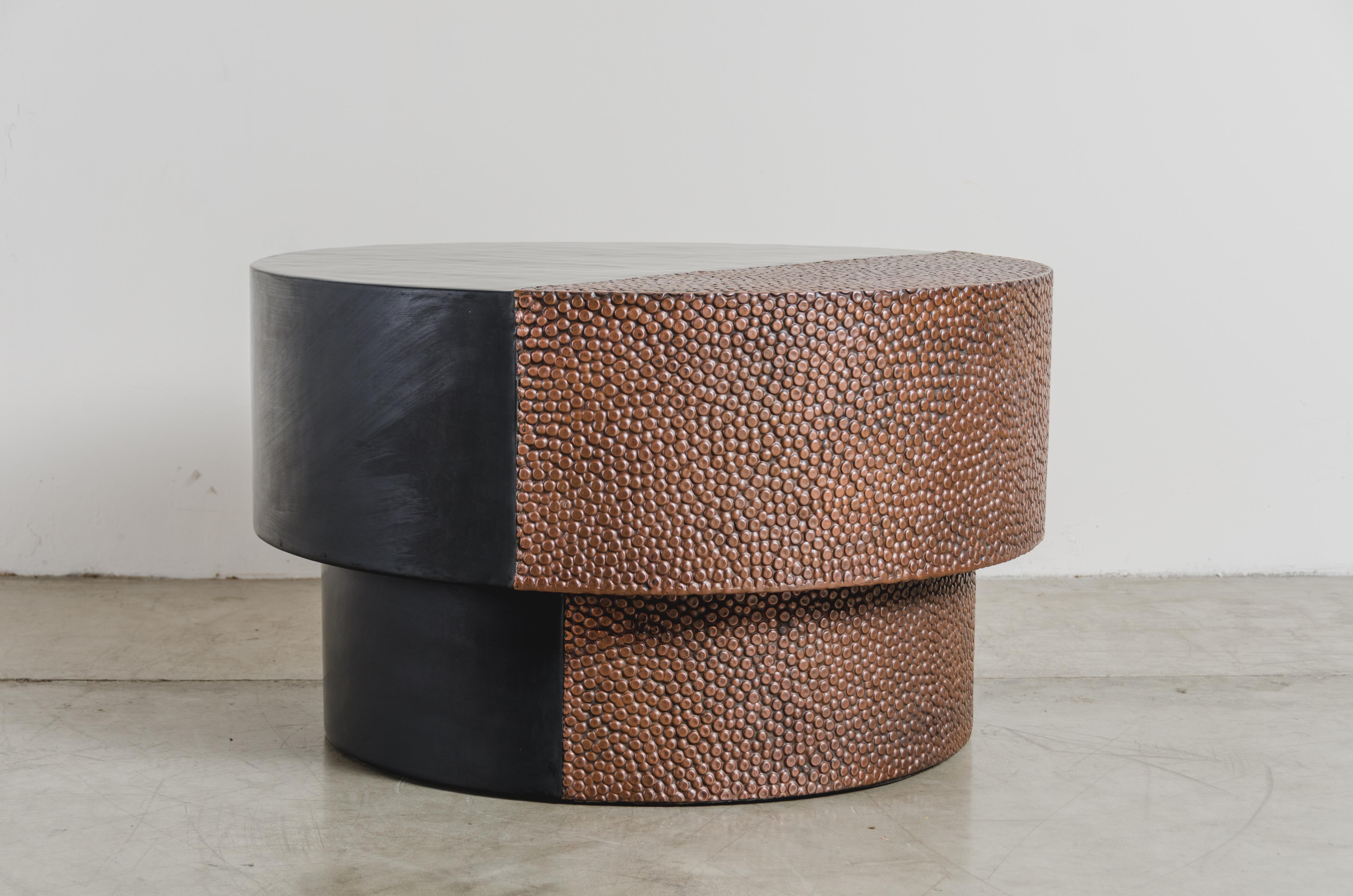 Drum table with toad skin design
Antique copper
Black copper
Hand repousse
Limited edition
Each piece is individually crafted and is unique.

Repousse is the traditional art of hand-hammering decorative relief onto sheet metal. The technique