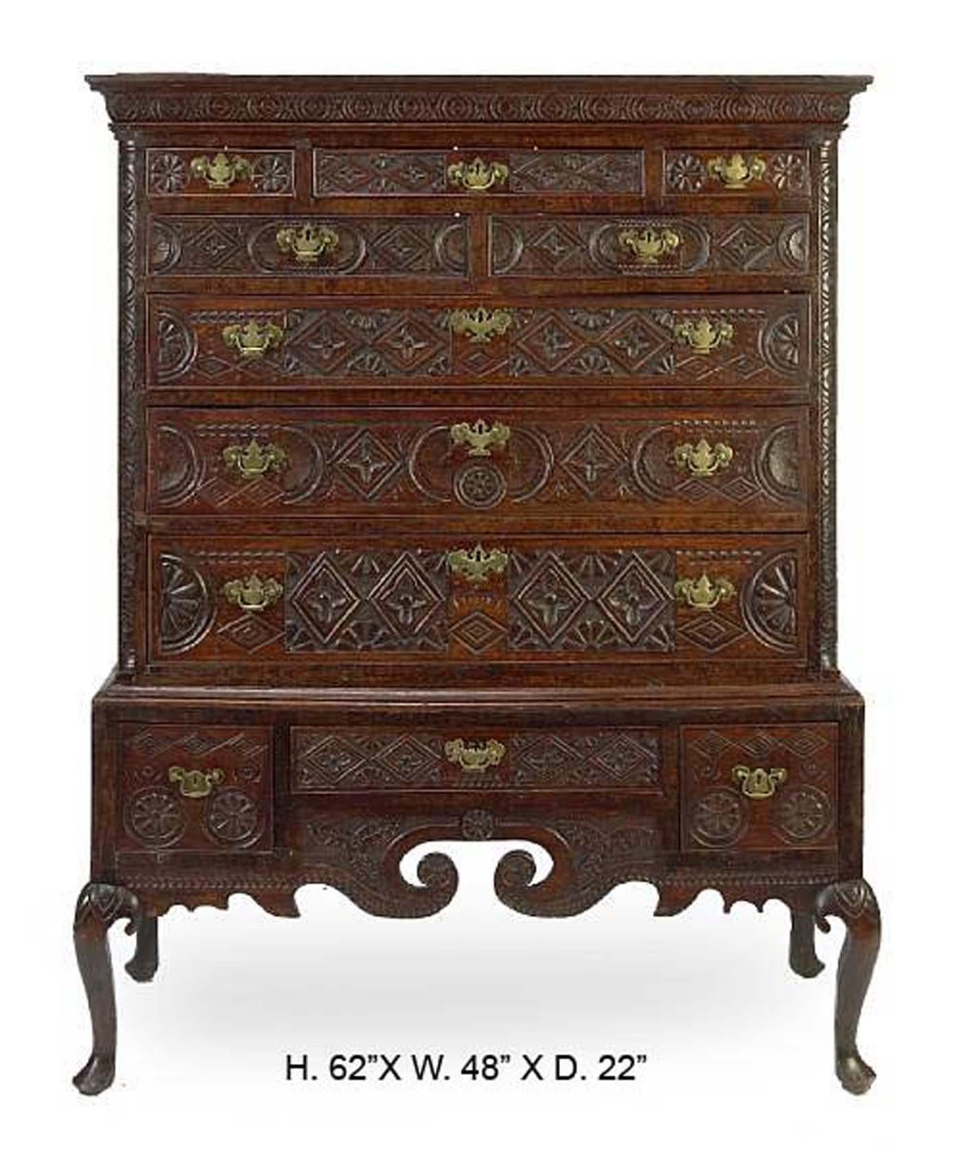 18th century George III carved oak highboy cabinet on stand.
The superstructure is topped by a moulded rectangular cornice over nine graduated drawers heavily carved with entrelacs and mounted with bronze handles, above a conforming support with