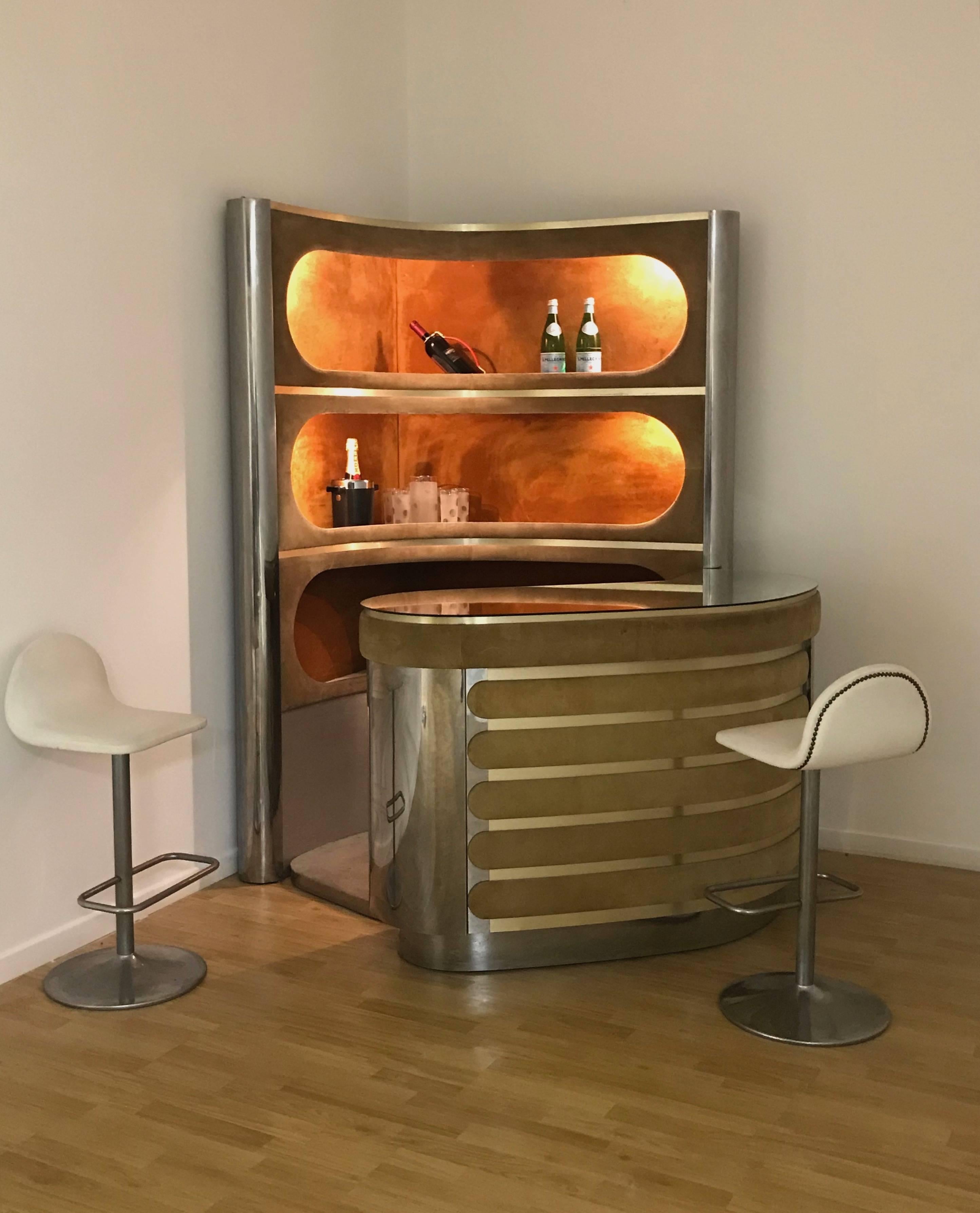 Illuminated bar and warehouse in the style of Willy Rizzo, Italy, early 1970s. The set includes a counter with a mirrored glass top, chrome sides and a suede front panel. A fridge is installed below. The storage unit offers three corner shelves,