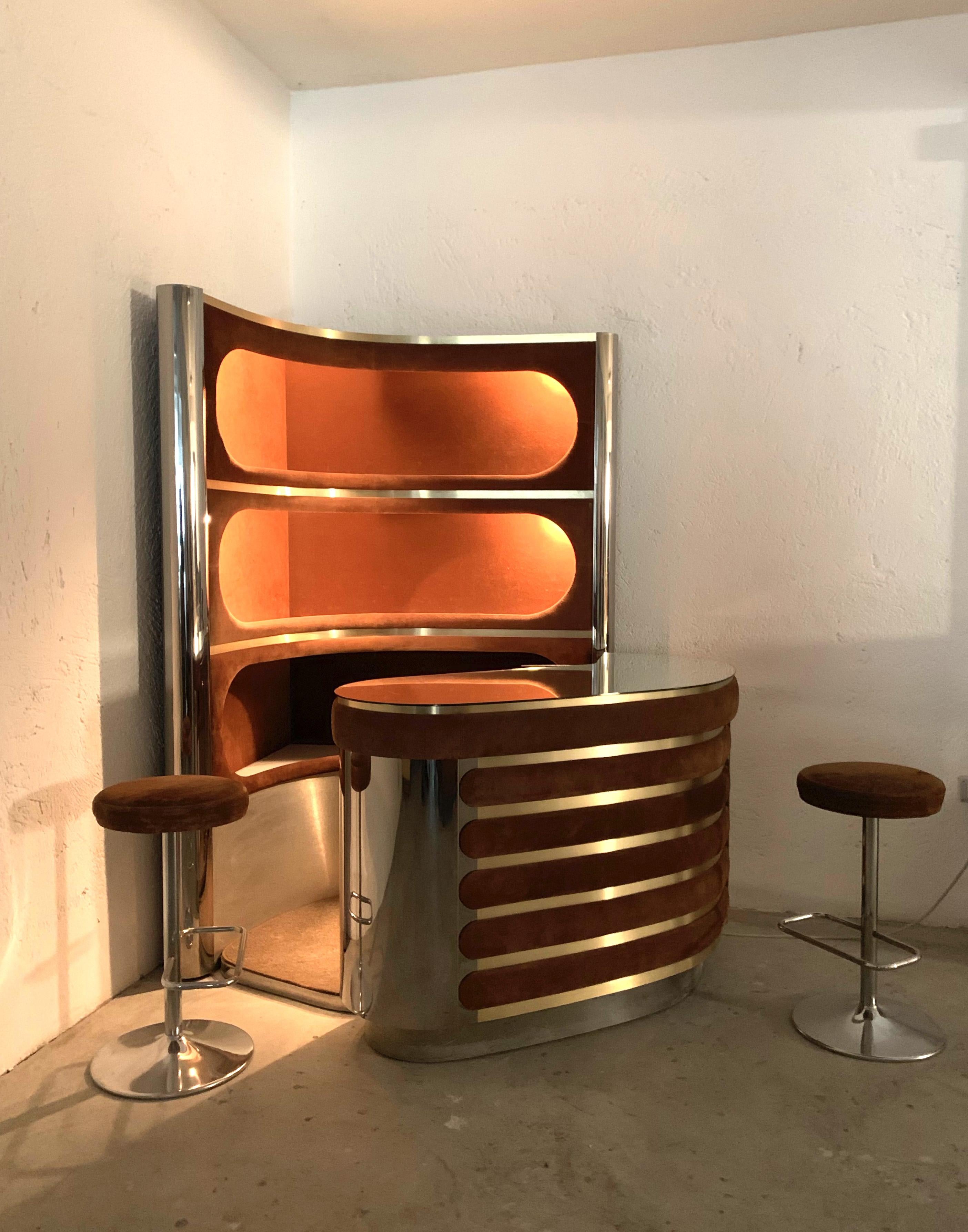 Illuminated bar and warehouse in the style of Willy Rizzo, Italy, early 1970s. The set includes a counter with a mirrored glass top, chrome sides and a suede front panel. A fridge is installed below. The storage unit offers three corner shelves,