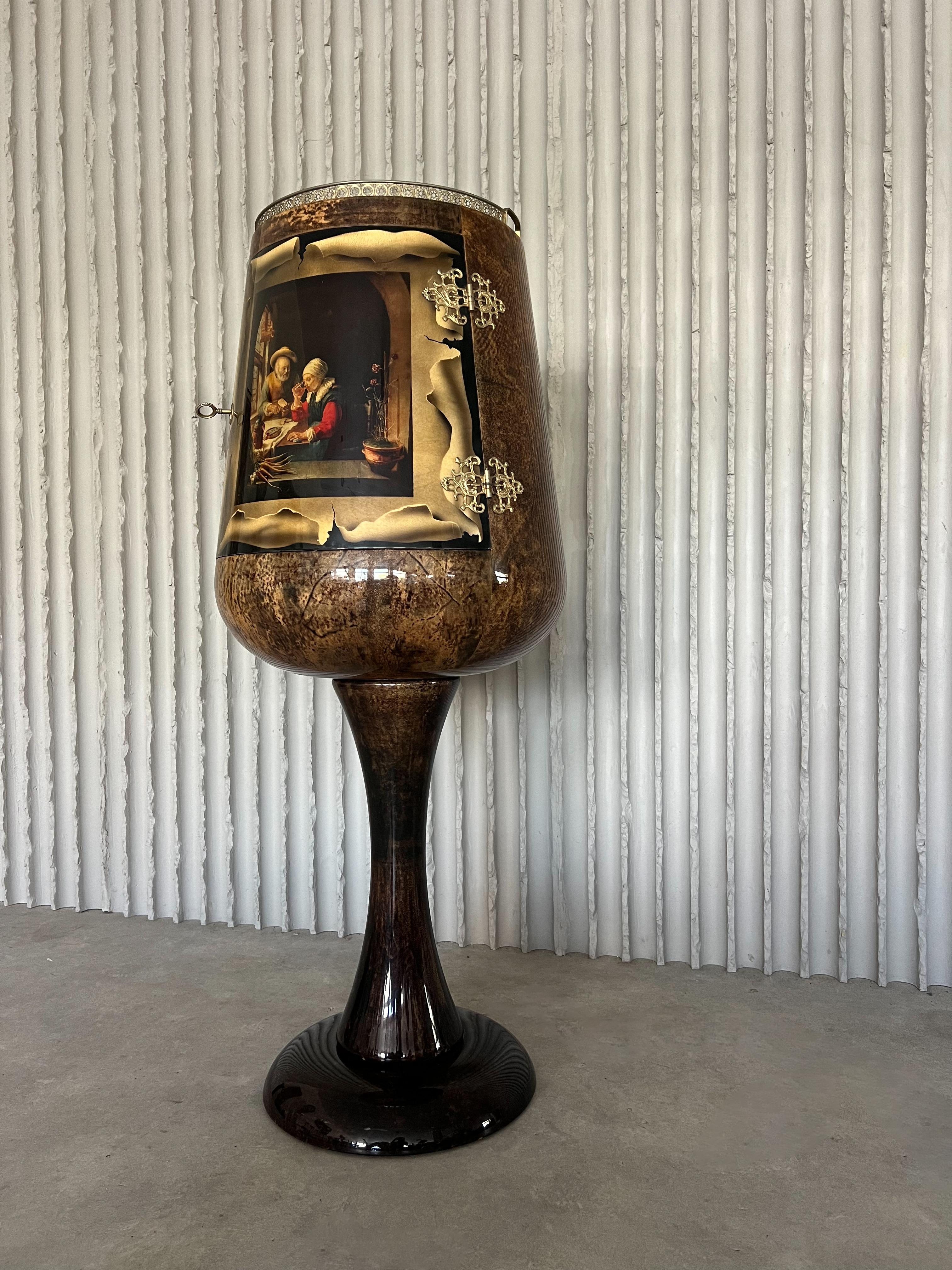 Bar à sec lumineux Calice d'Aldo Tura, Italie, années 1960. Ce bar sec en peau de chèvre laquée, typique d'Aldo Tura, est un véritable objet de conversation. Avec sa scène médiévale peinte sur la porte, ses magnifiques détails en laiton (swipez pour