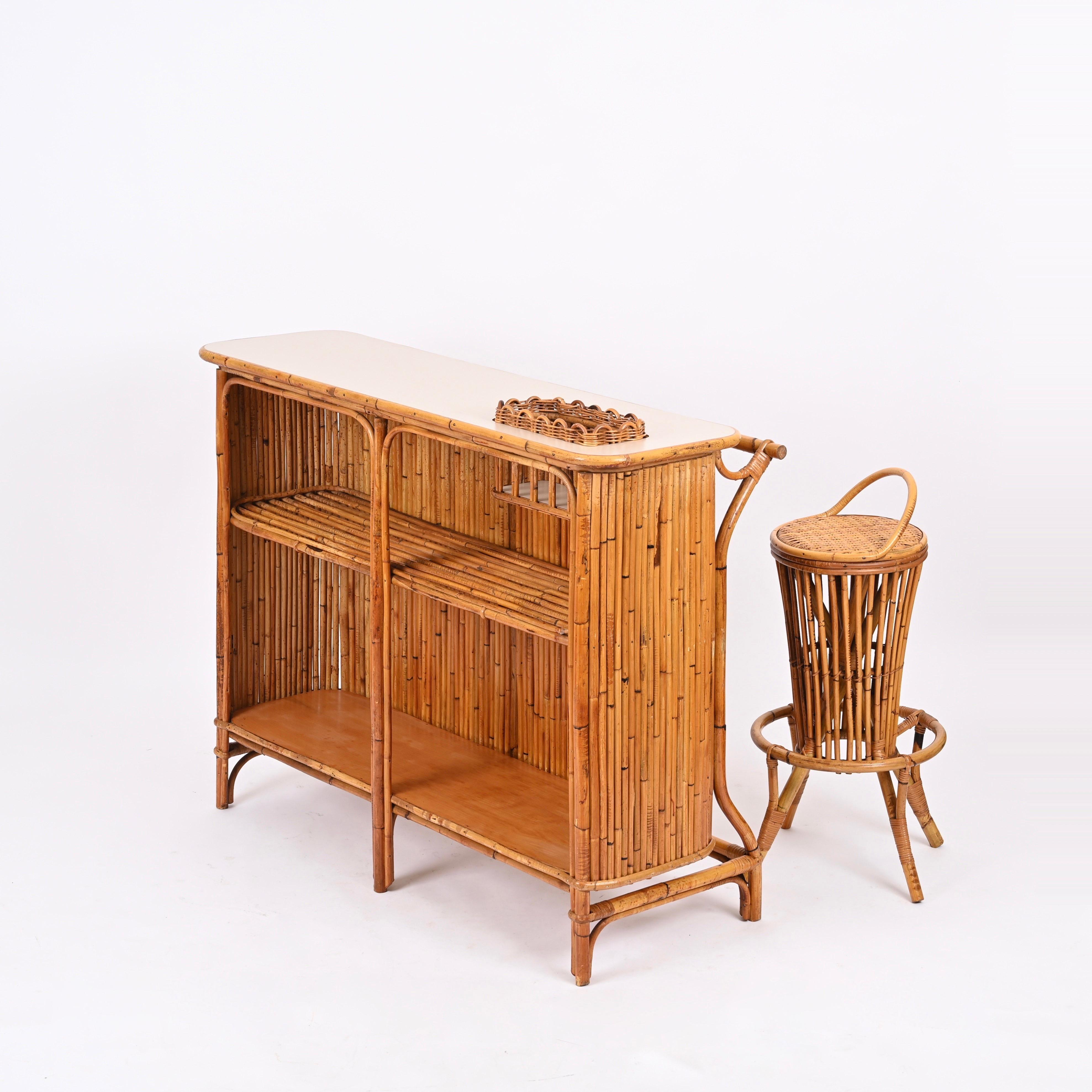 Marvelous Mid-Century dry bar with two stools made in a gorgeous mix of bamboo, rattan, wicker and white formica. This charming bar was designed by Tito Agnoli and made in Italy during the 1950s.

Fully original and in spectacular conditions. This