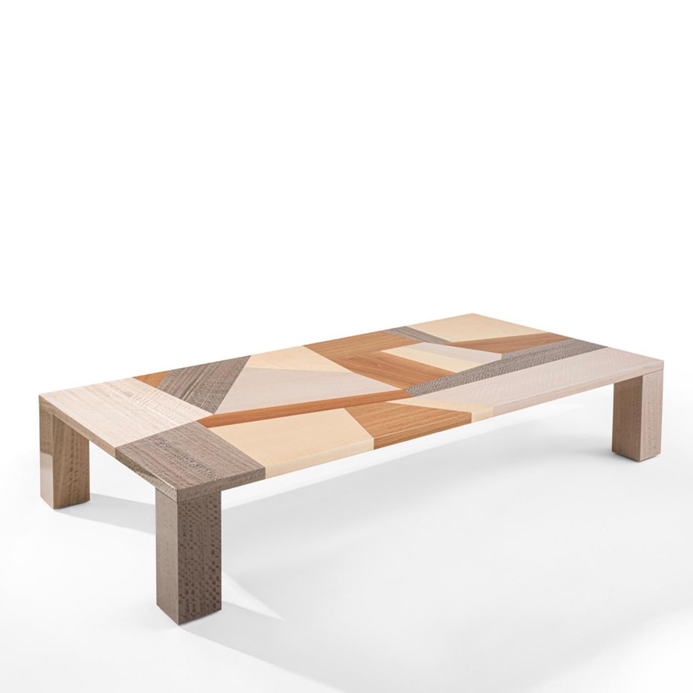 A clever arrangement of vibrant wood inlays in contrasting tones blending cool, neutral, and warm shades lends this coffee table its superb dynamism, emphasized by the inlays' sharp and irregular cut. The extremely minimalist silhouette