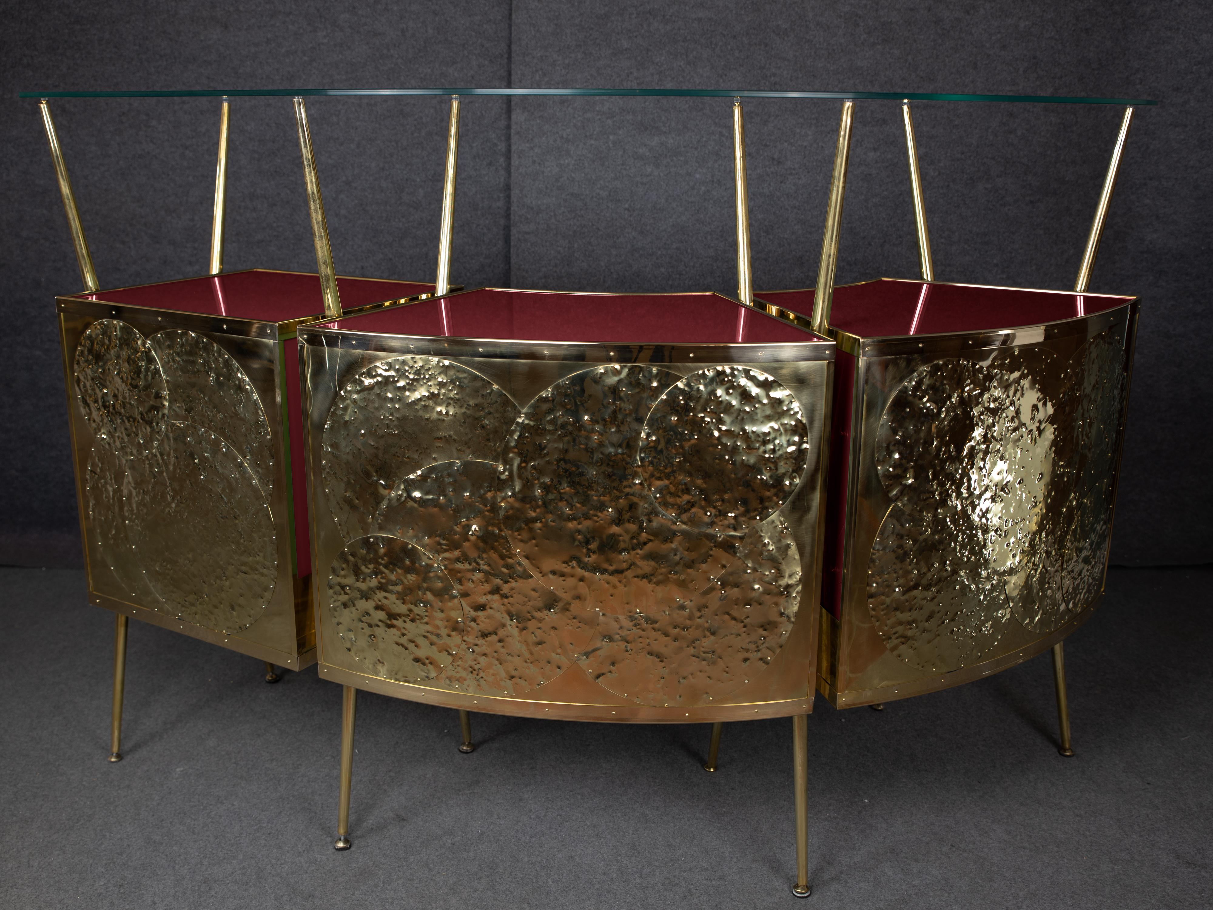 This stunning dry bar, inspired by the style of Gio Ponti, combines mid-century modern elegance with exceptional craftsmanship. 

Made in Italy, it features steam-curved wood, polished brass and red Murano tempered glass to ensure both aesthetics