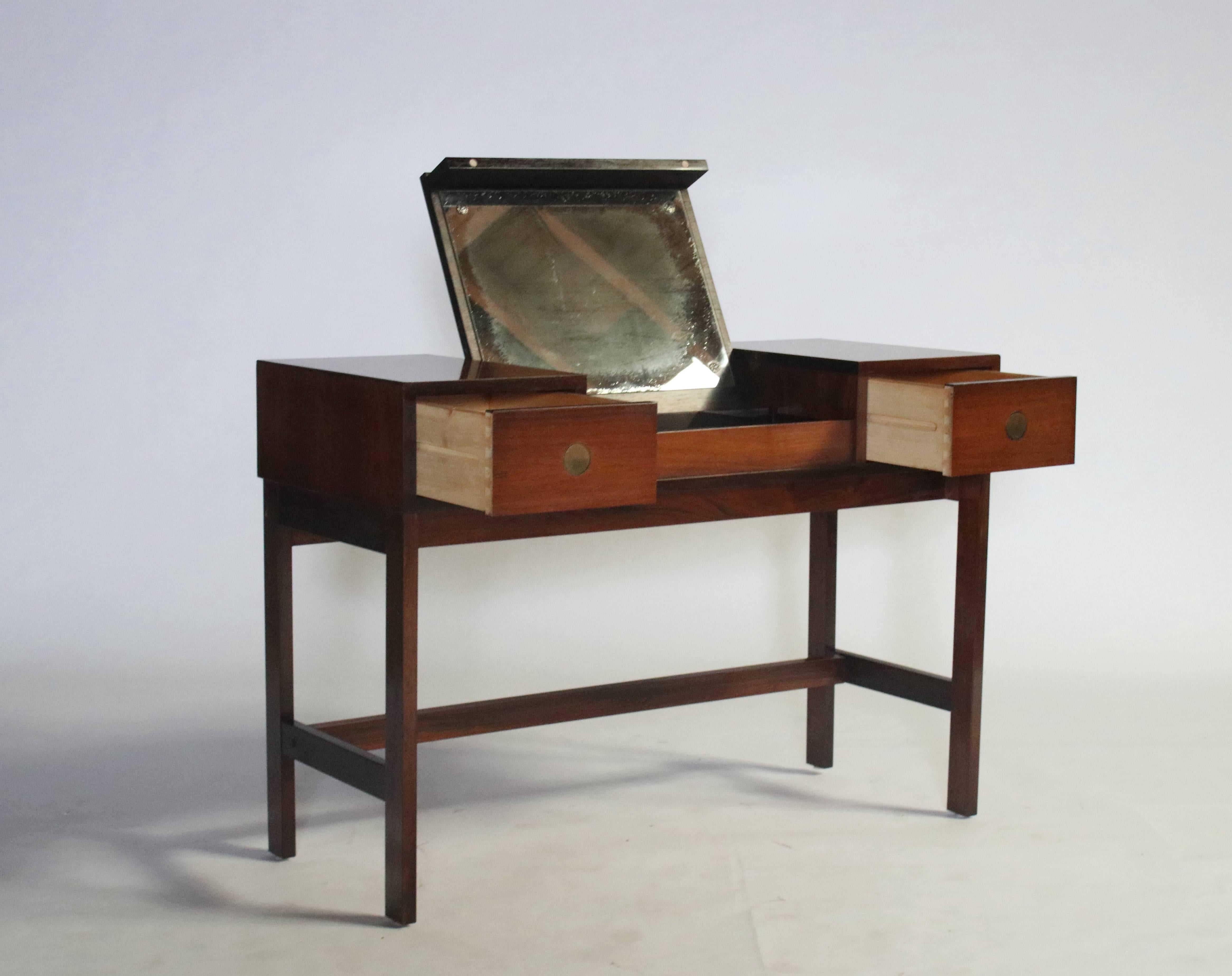 Midcentury rosewood vanity by Drylund, Denmark features a lift-up drawer revealing a make-up mirror and compartments for storage. Two pull-out drawers provide for additional storage.