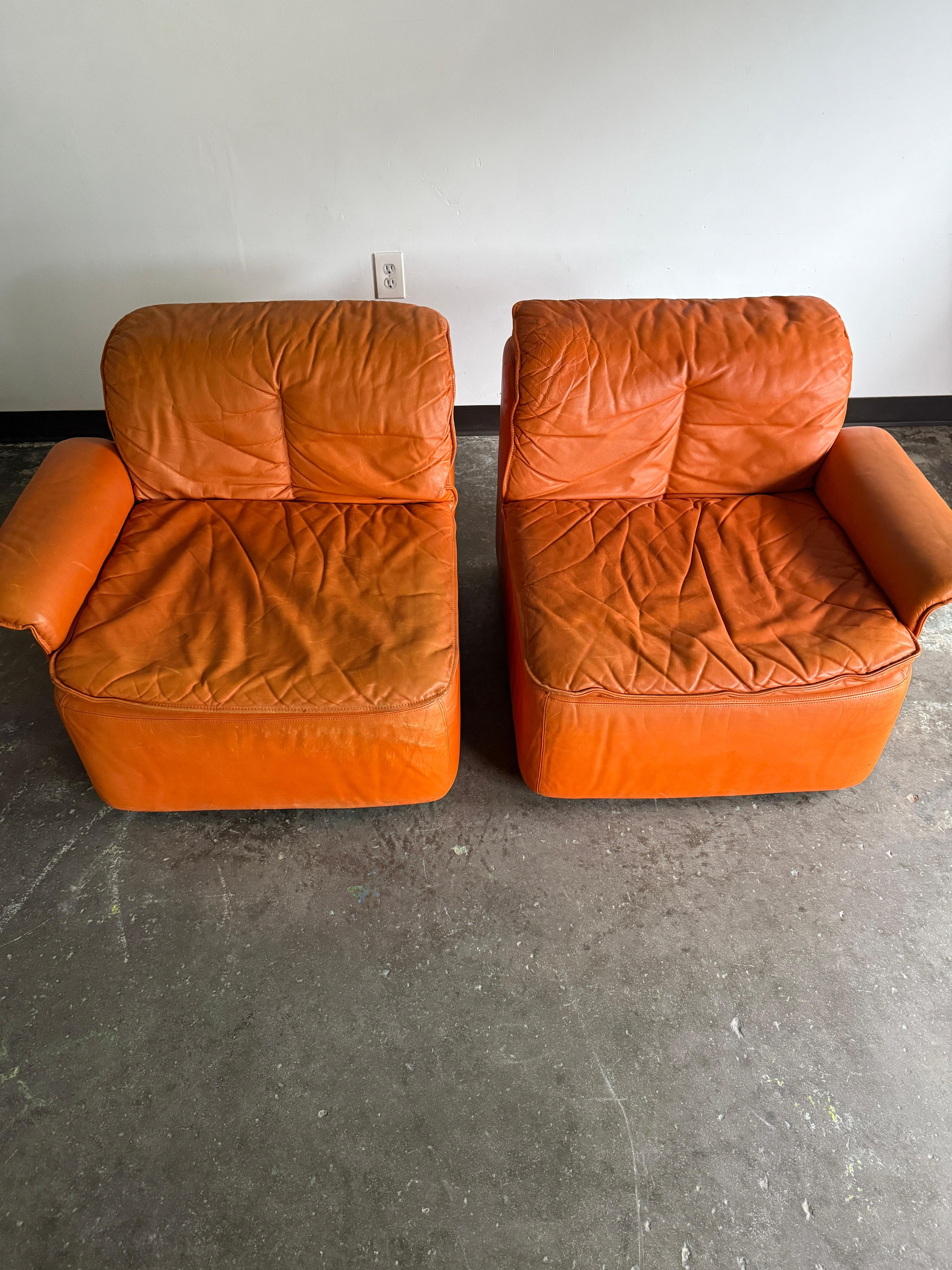 DS12 De Sede two-piece modular sofa in an orange-hued colorway. The seats can be attached underneath with a locking mechanism or situated separately as two chairs. In excellent vintage condition with minor signs of wear due to use.