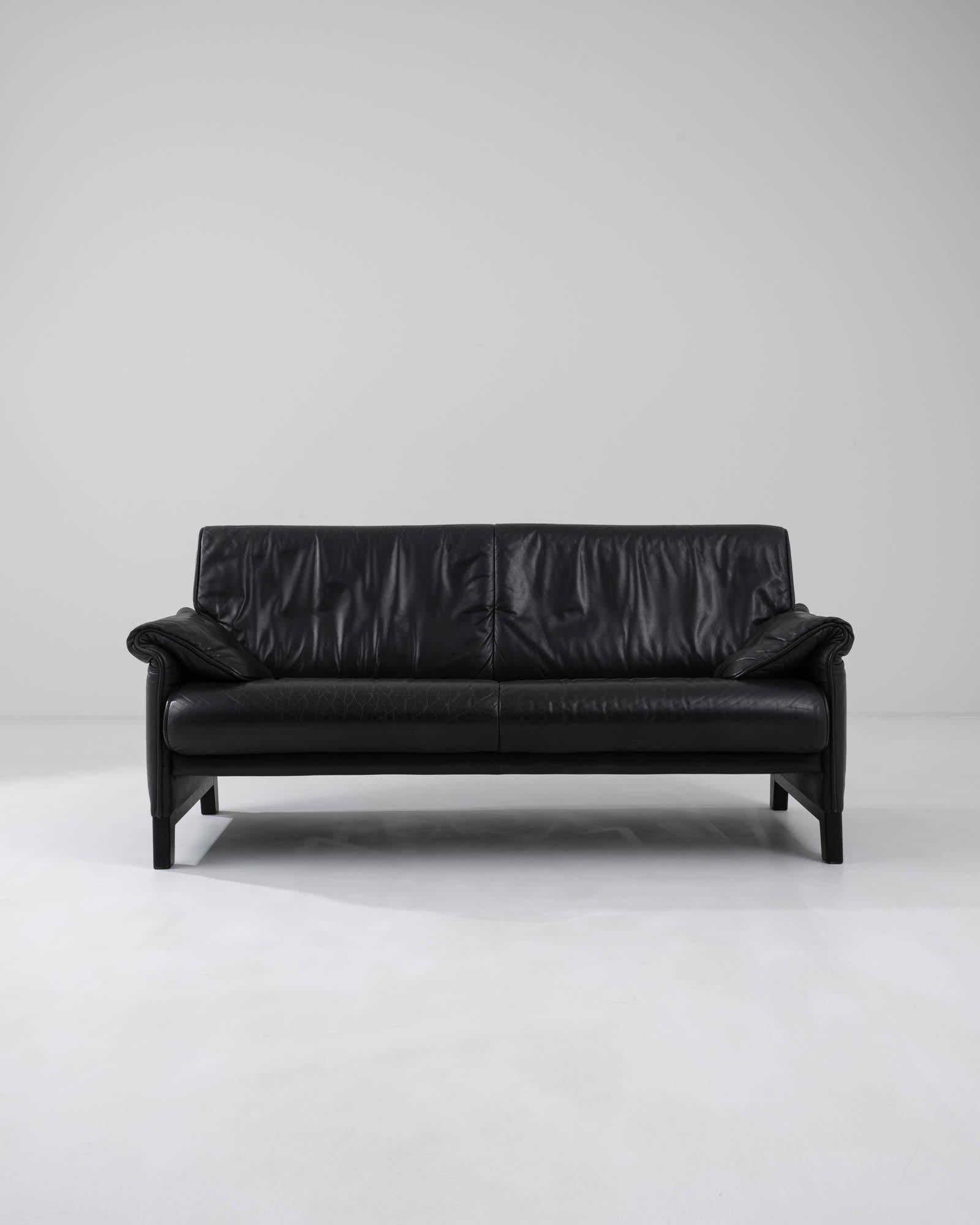 Hand-made in Switzerland by renowned furniture manufacturers De Sede, this Modernist leather sofa is simultaneously sophisticated and playful. The armrests double over themselves in soft, slouchy folds, giving a relaxed inflection to the otherwise